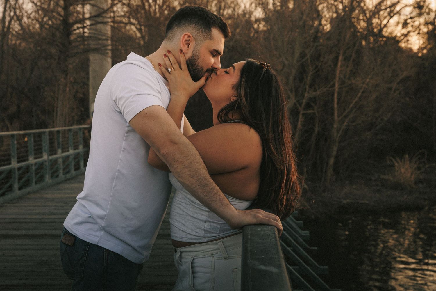 A romantic sunset photoshoot on a dock with autumn trees in background.