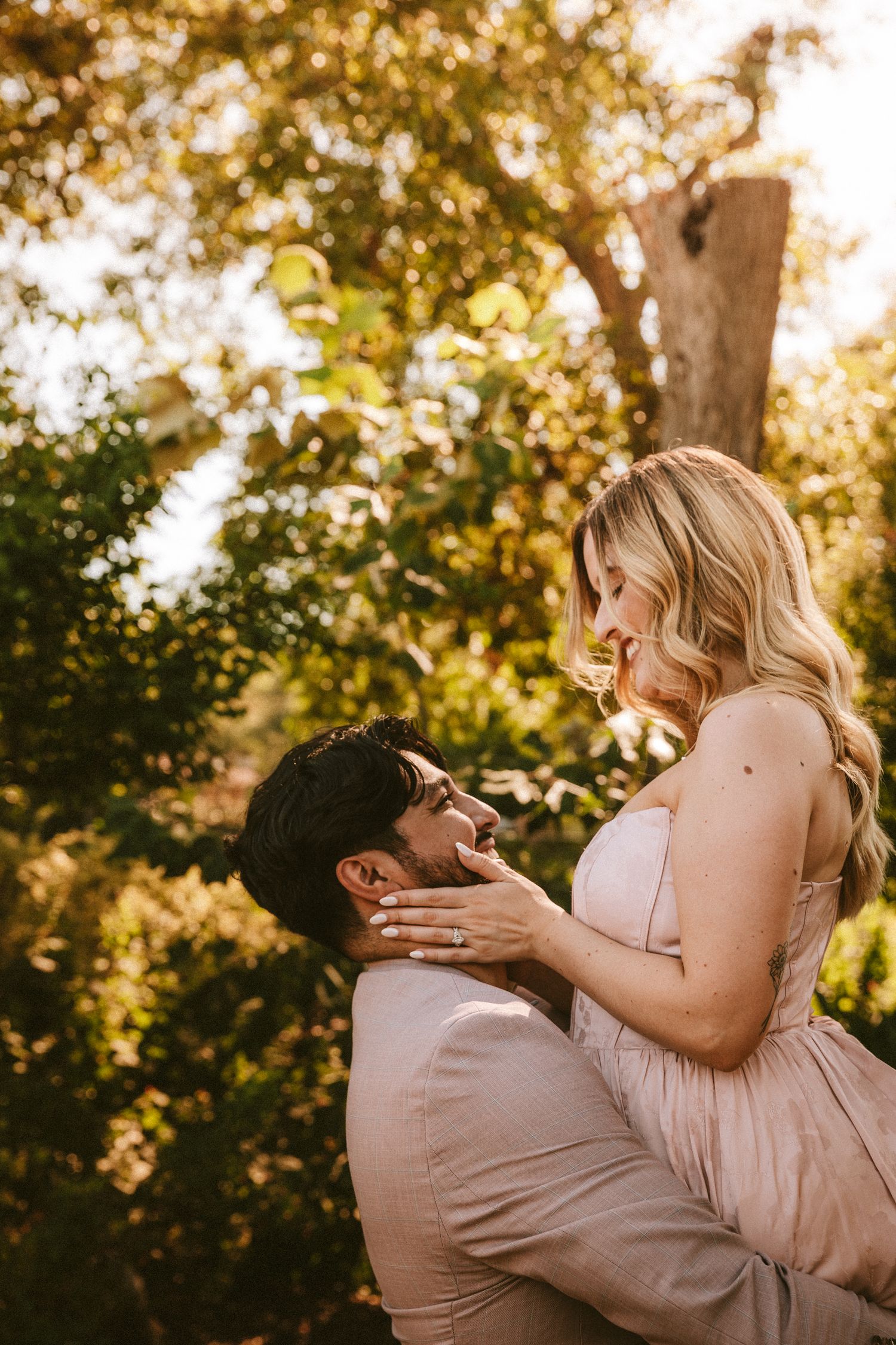 A playful moment captured in golden sunlight with trees in the background.