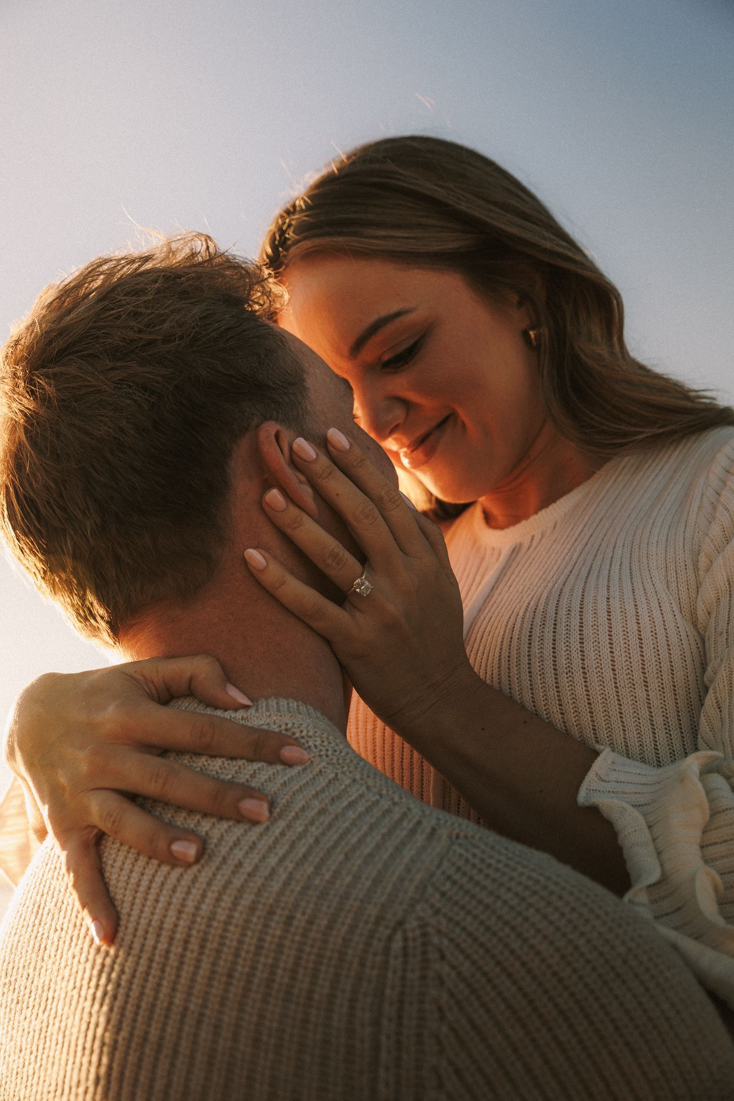 Romantic couple sharing intimate moments during golden hour sunset.