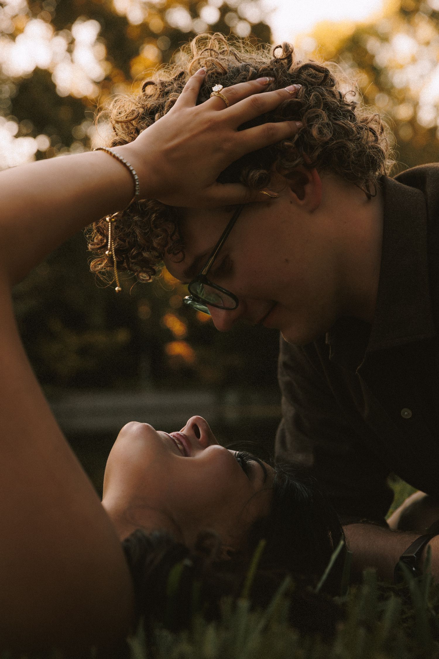 Intimate portrait session at sunset with soft golden lighting through trees.