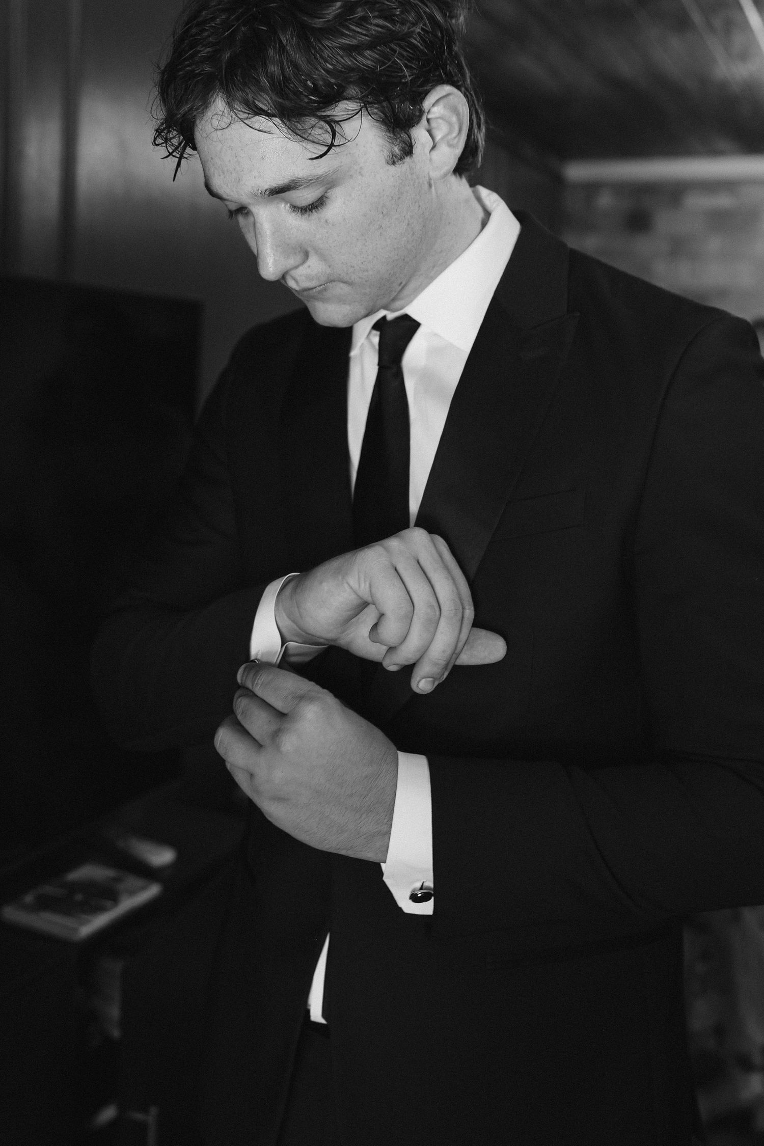 Classic black and white photograph showing details of a formal suit and tie.