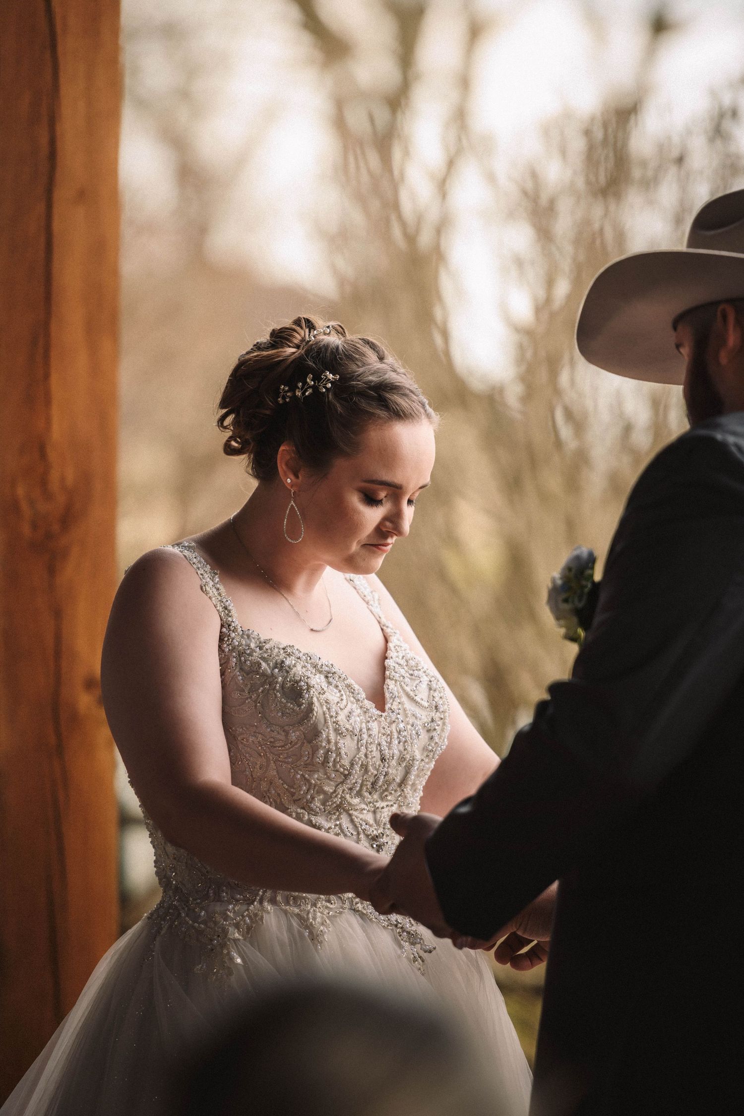 A wedding ceremony under a wooden pavilion with soft natural lighting and romantic atmosphere.