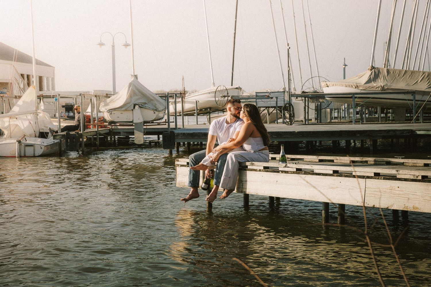 A romantic waterfront scene with boats and docks at dusk.