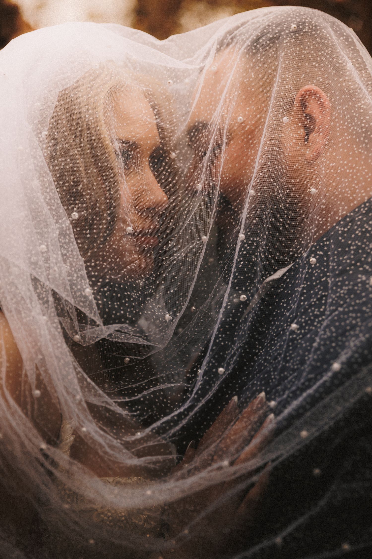 A series of dark artistic photos showing figures behind translucent veils creating a dreamy, ethereal atmosphere.
