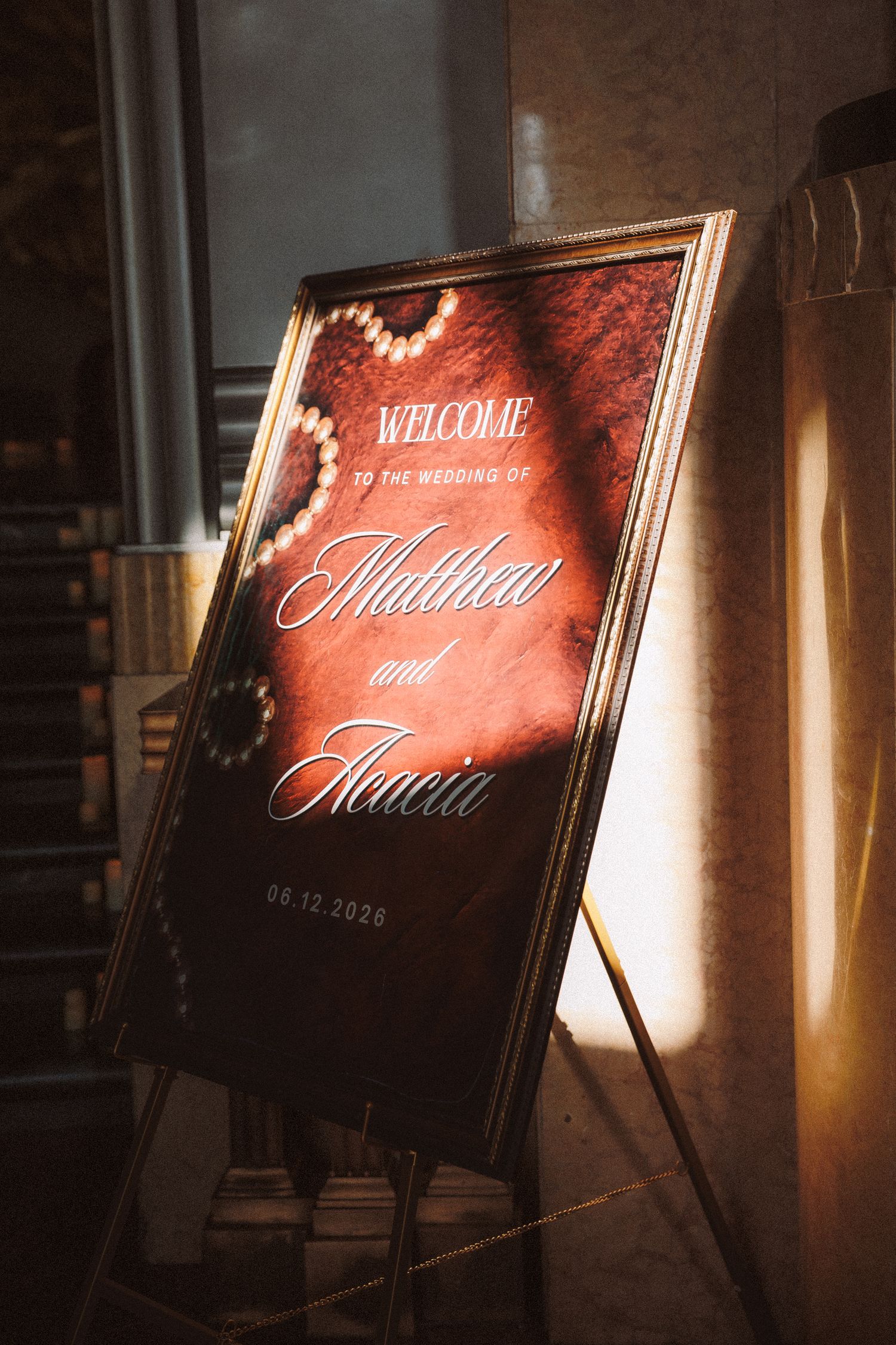 Elegant wedding welcome sign for Matthea and Ilacia dated 06.12.2026 in ornate gold frame.