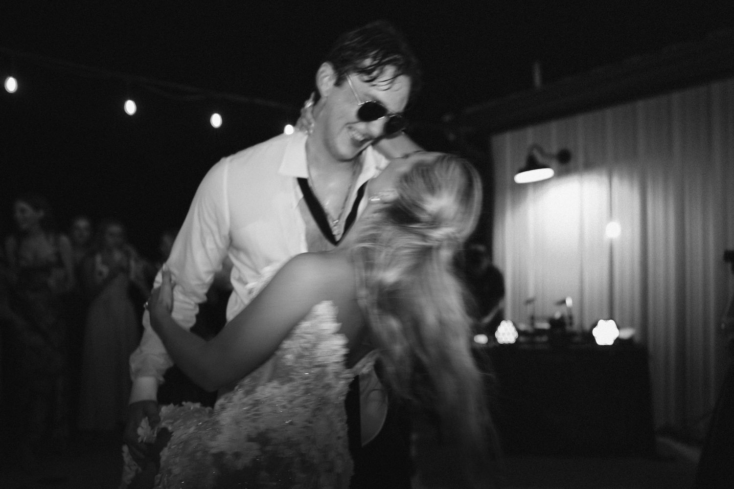 Dark evening wedding reception photos with string lights creating a moody atmosphere.