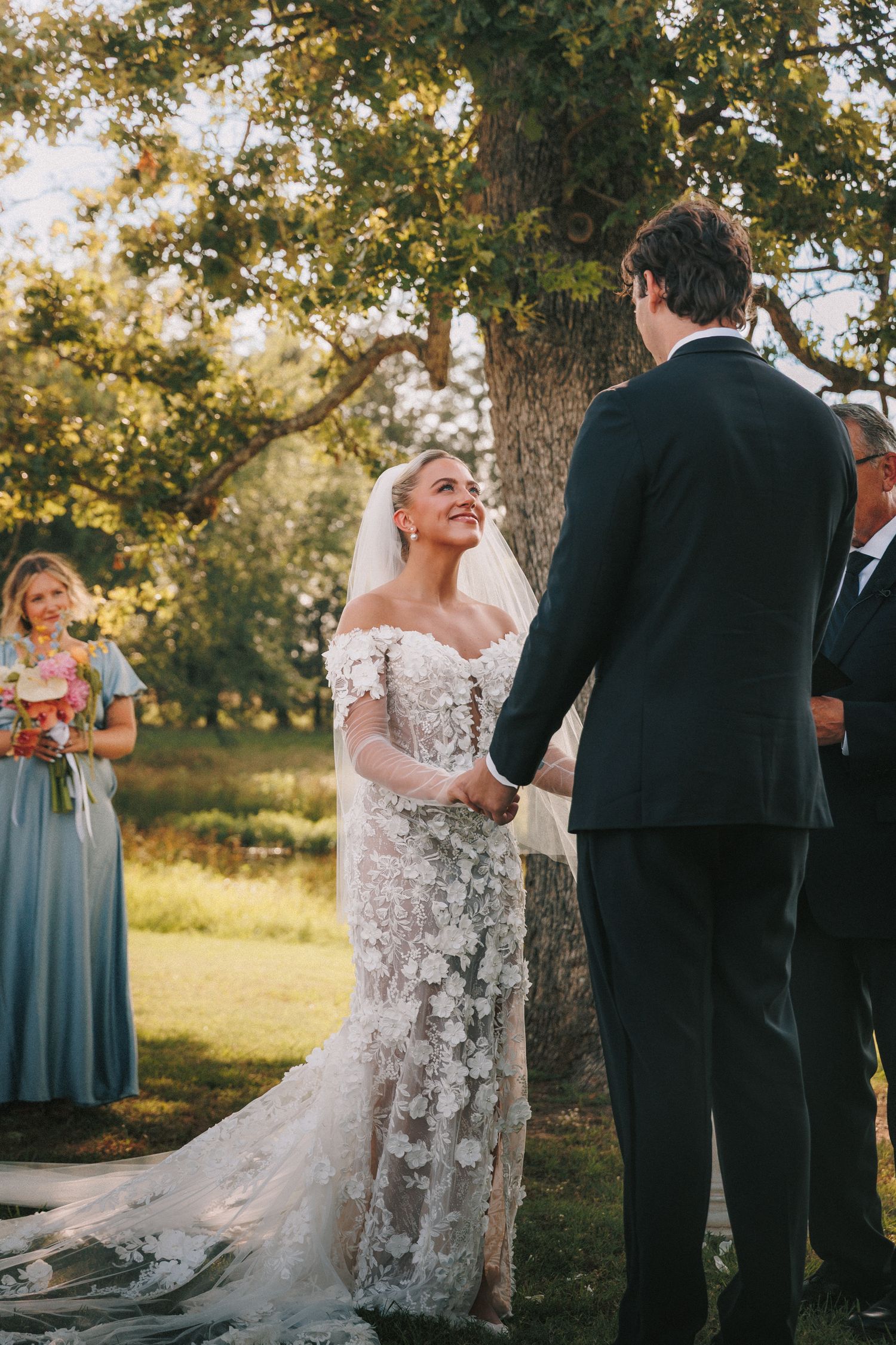 Outdoor wedding ceremony in a garden setting with a lace wedding gown and romantic lighting.