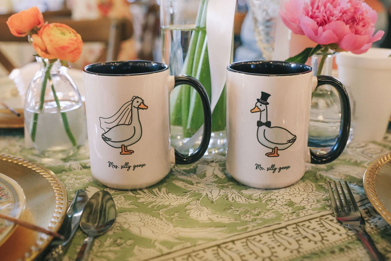 Row of matching coffee mugs with duck designs displayed on a textured placemat.