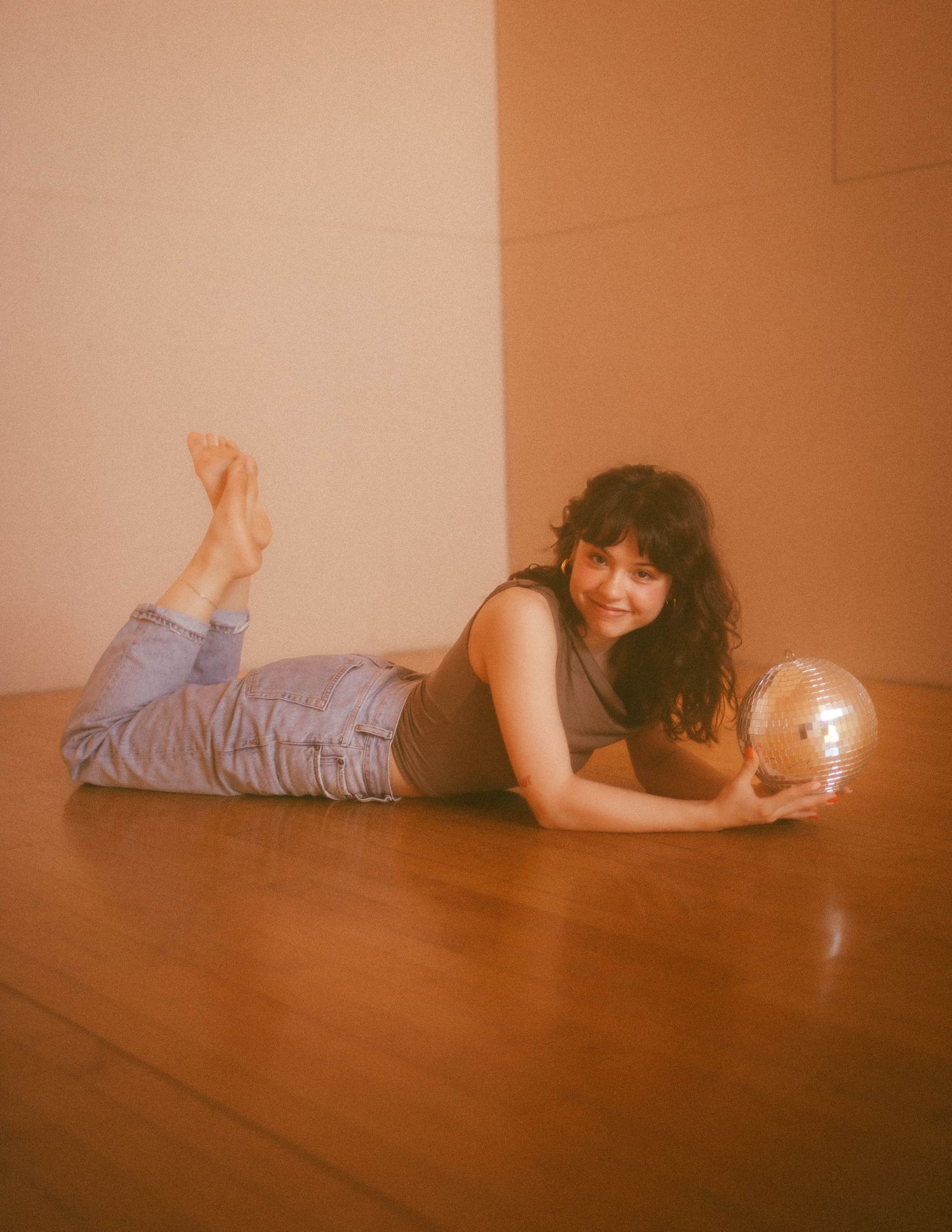 Person laying on wooden floor in moody orange-tinted room with sliding movement effect captured in sequence.