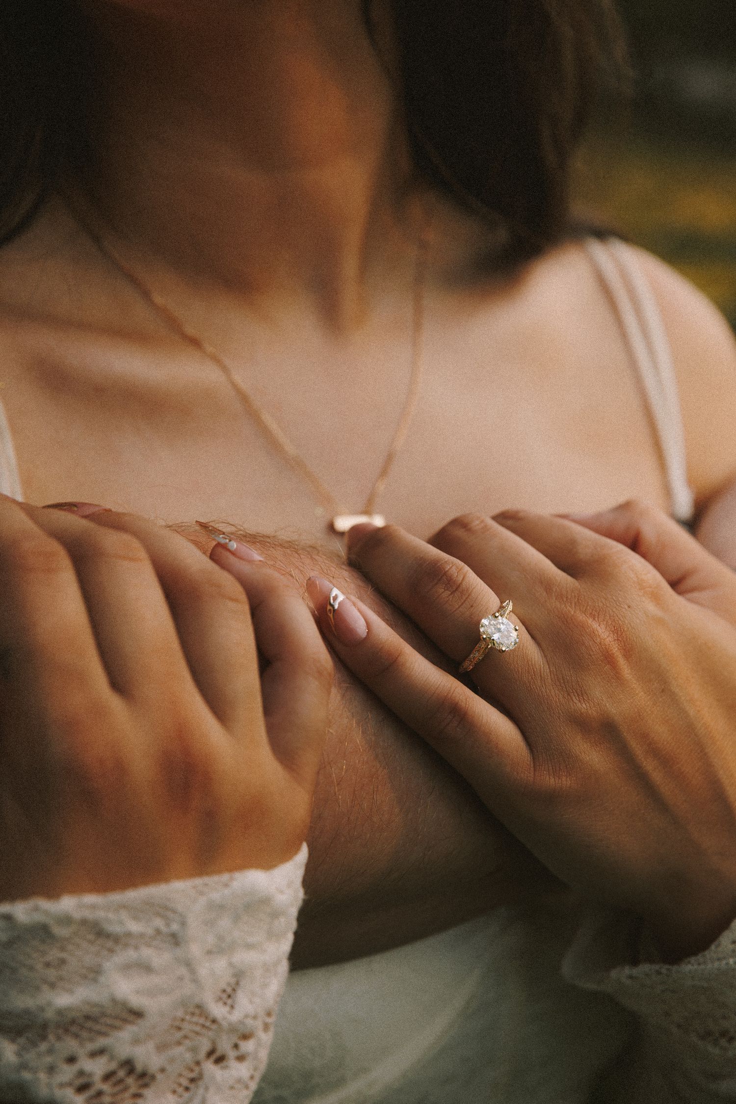 Close-up sequence of hands displaying an engagement ring with a sparkling diamond solitaire against a soft blurred background.