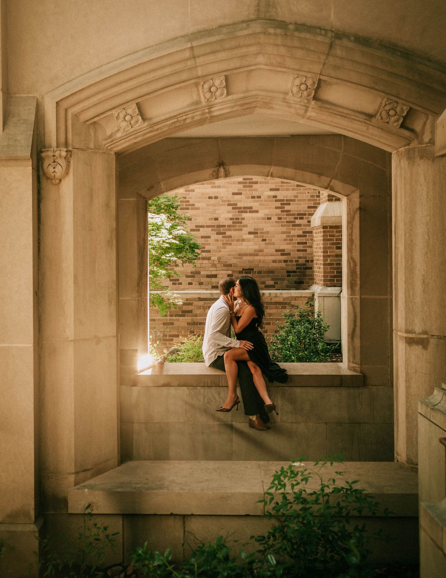 A romantic evening scene under an ornate stone archway with candlelight and climbing vines framing the intimate setting.
