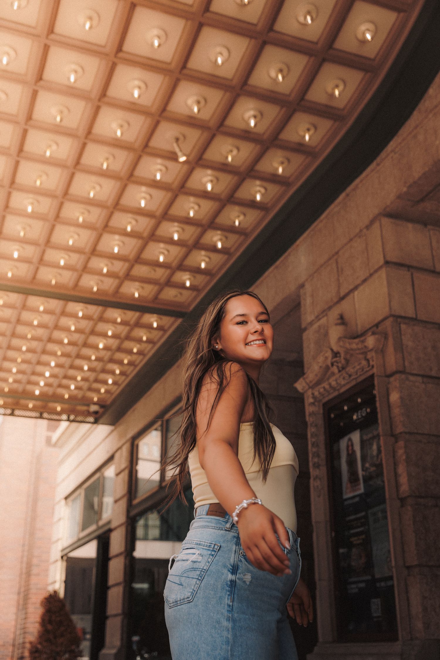 Fashion portrait shot under decorative ceiling lighting with retro architectural details.
