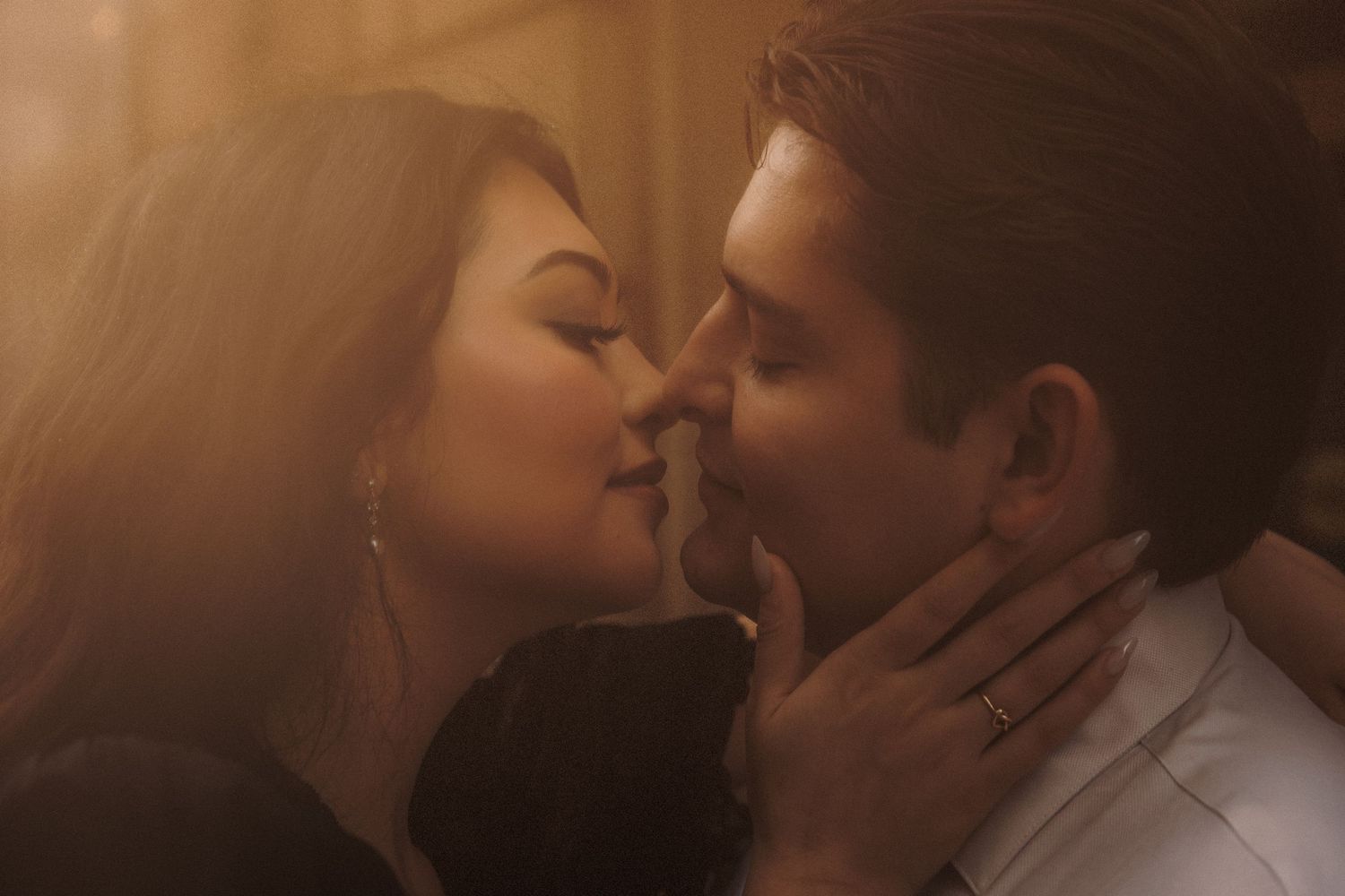 A romantic couple sharing an intimate kiss in warm golden light, perfect for love and romance themes.