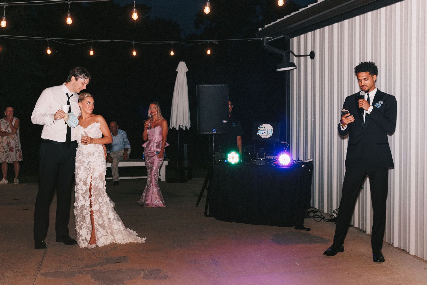 Wedding reception venue decorated with string lights and white walls.
