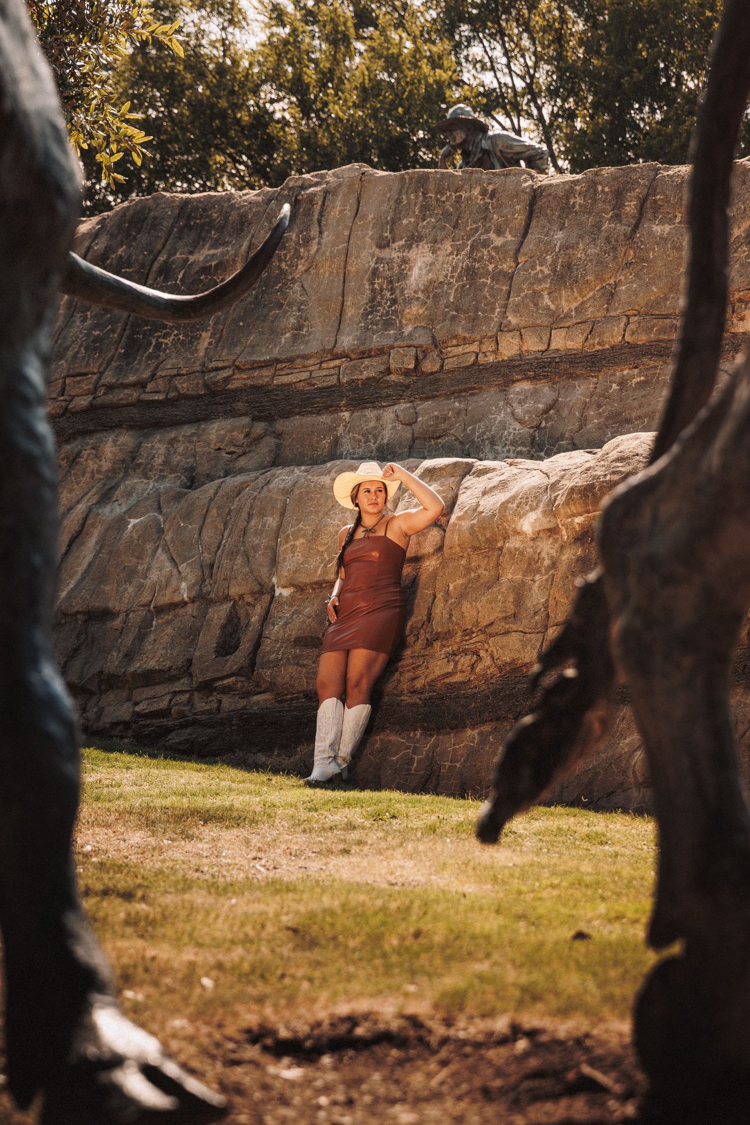 A sequence of four photos showing a person bouldering on a large rock wall in autumn sunlight.