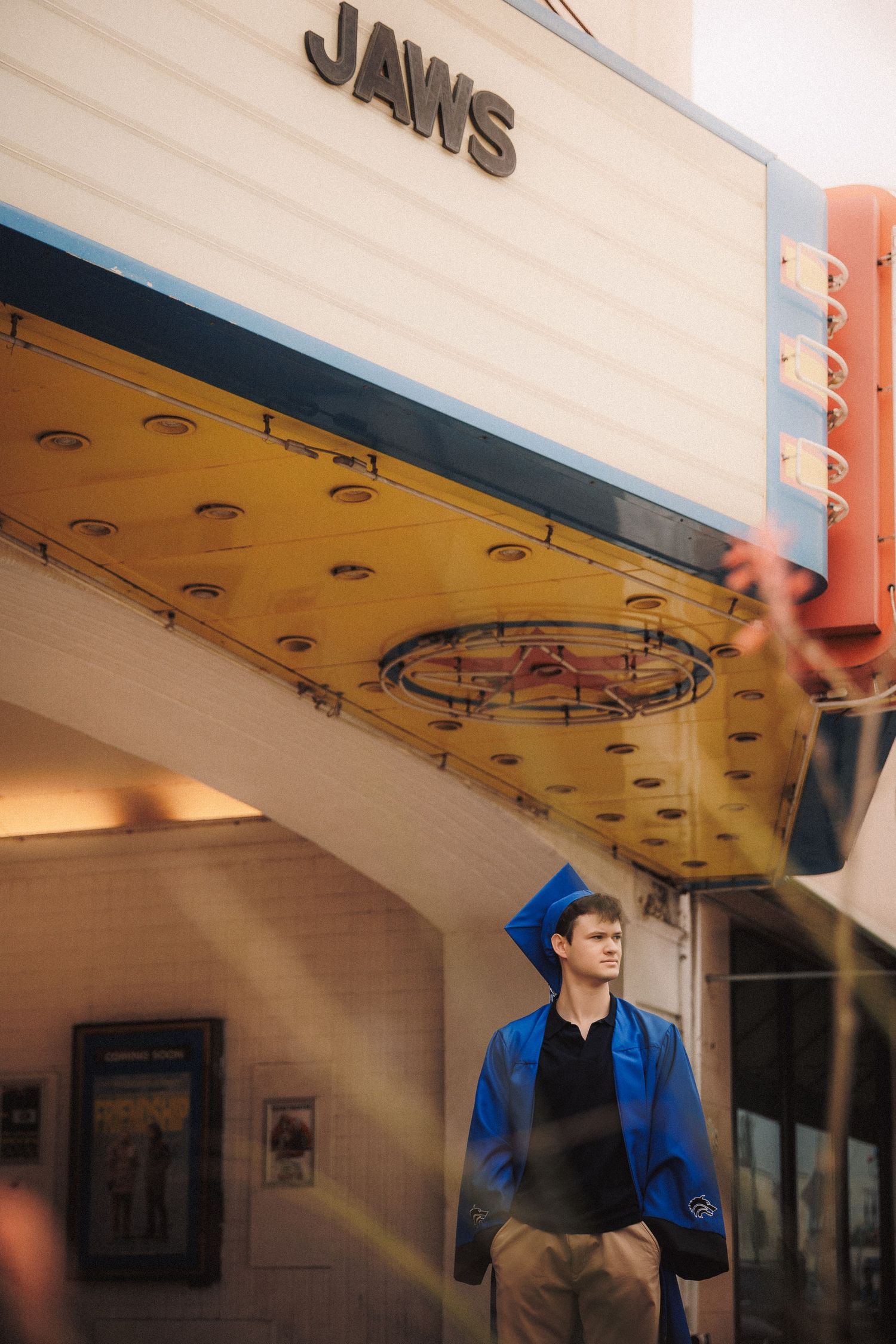 A vintage movie theater entrance with 'JAWS' signage and yellow underlit overhang on display.