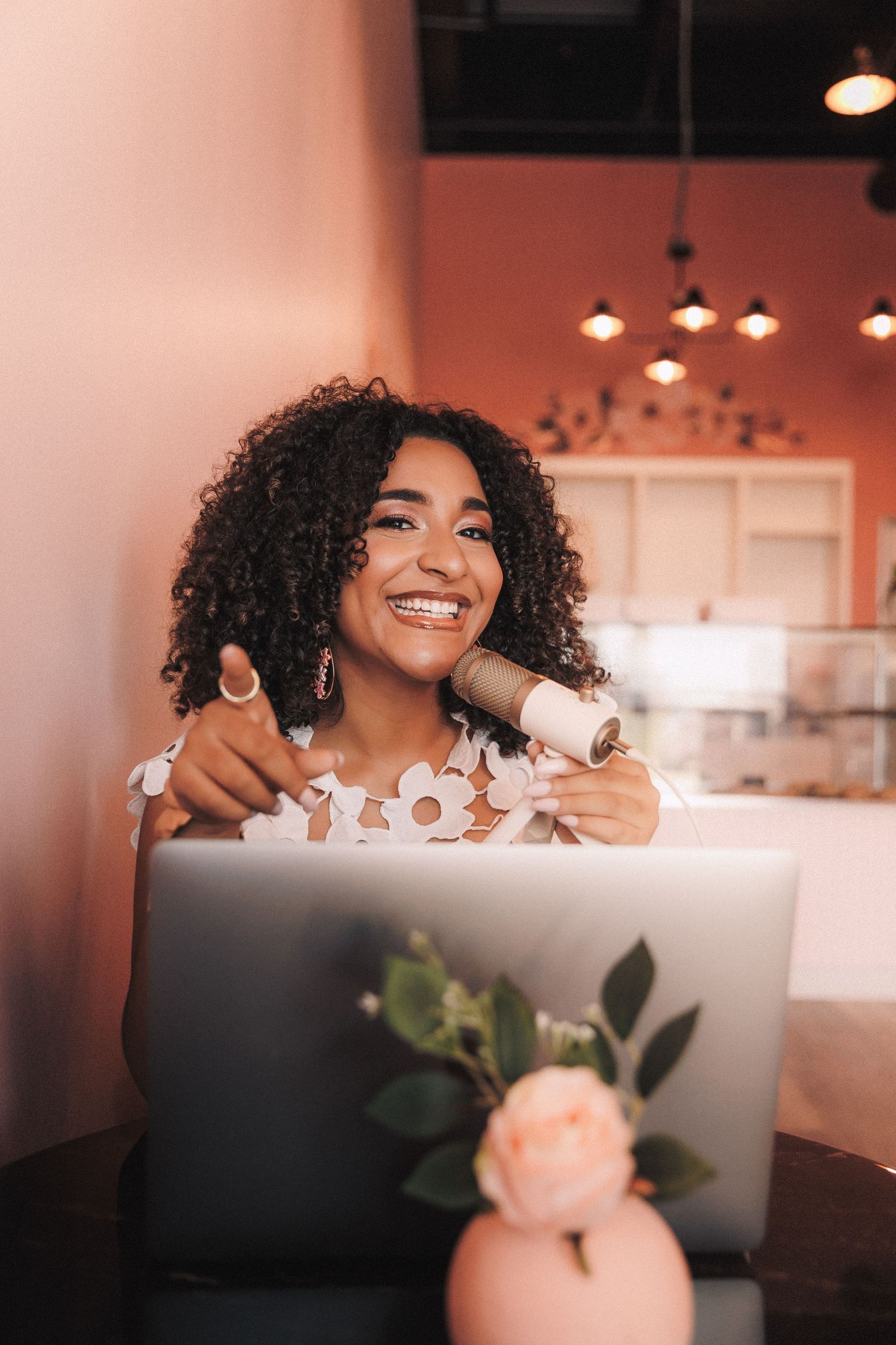 A joyful expression and curly hair shown in four connected candid moments in a softly lit interior space.
