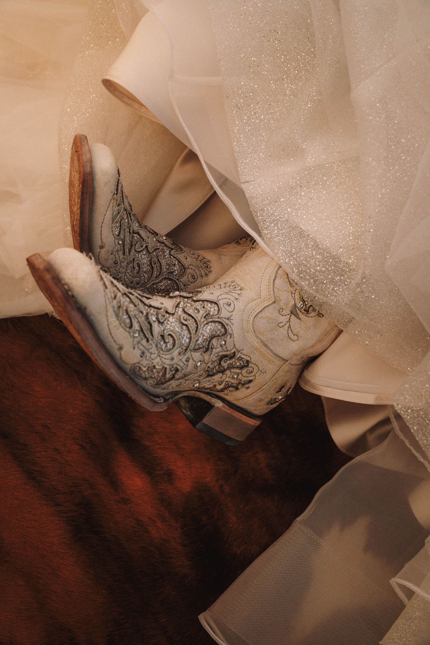 Close-up sequence of intricate lace and embroidery details on a white wedding shoe against a dark wooden surface.