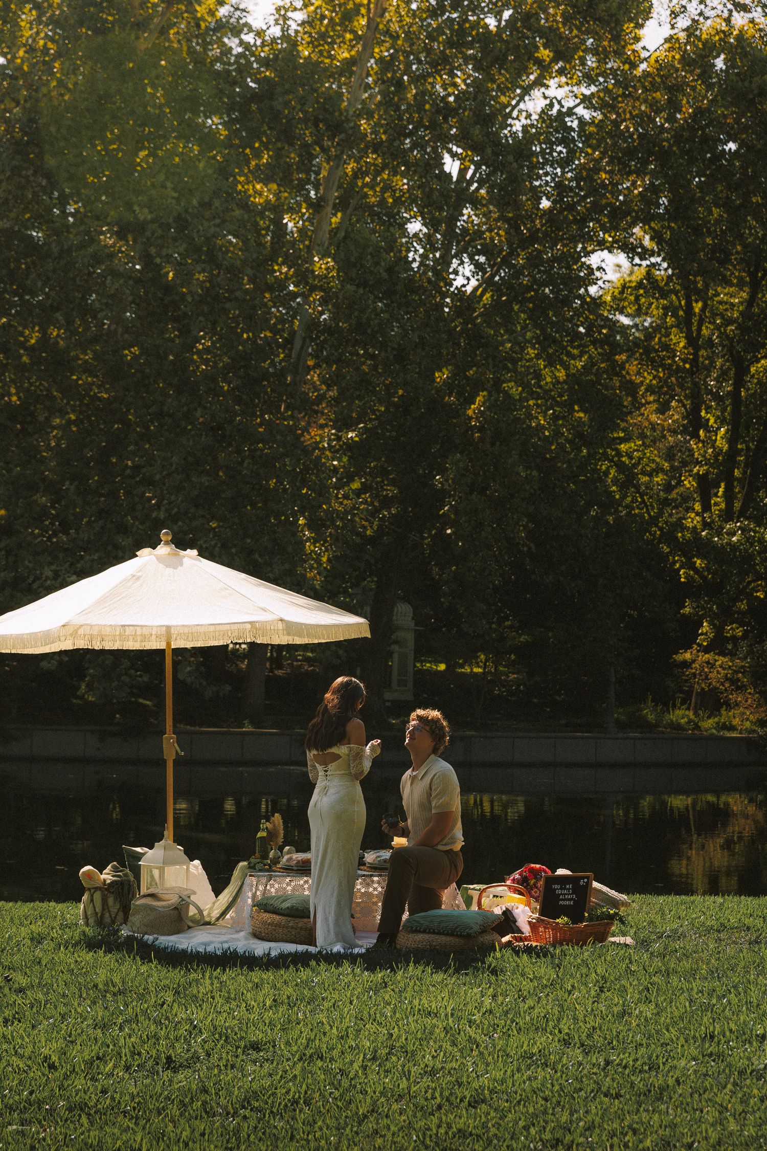 People relaxing on a grassy lawn under white parasol umbrellas during a sunny afternoon in the park.