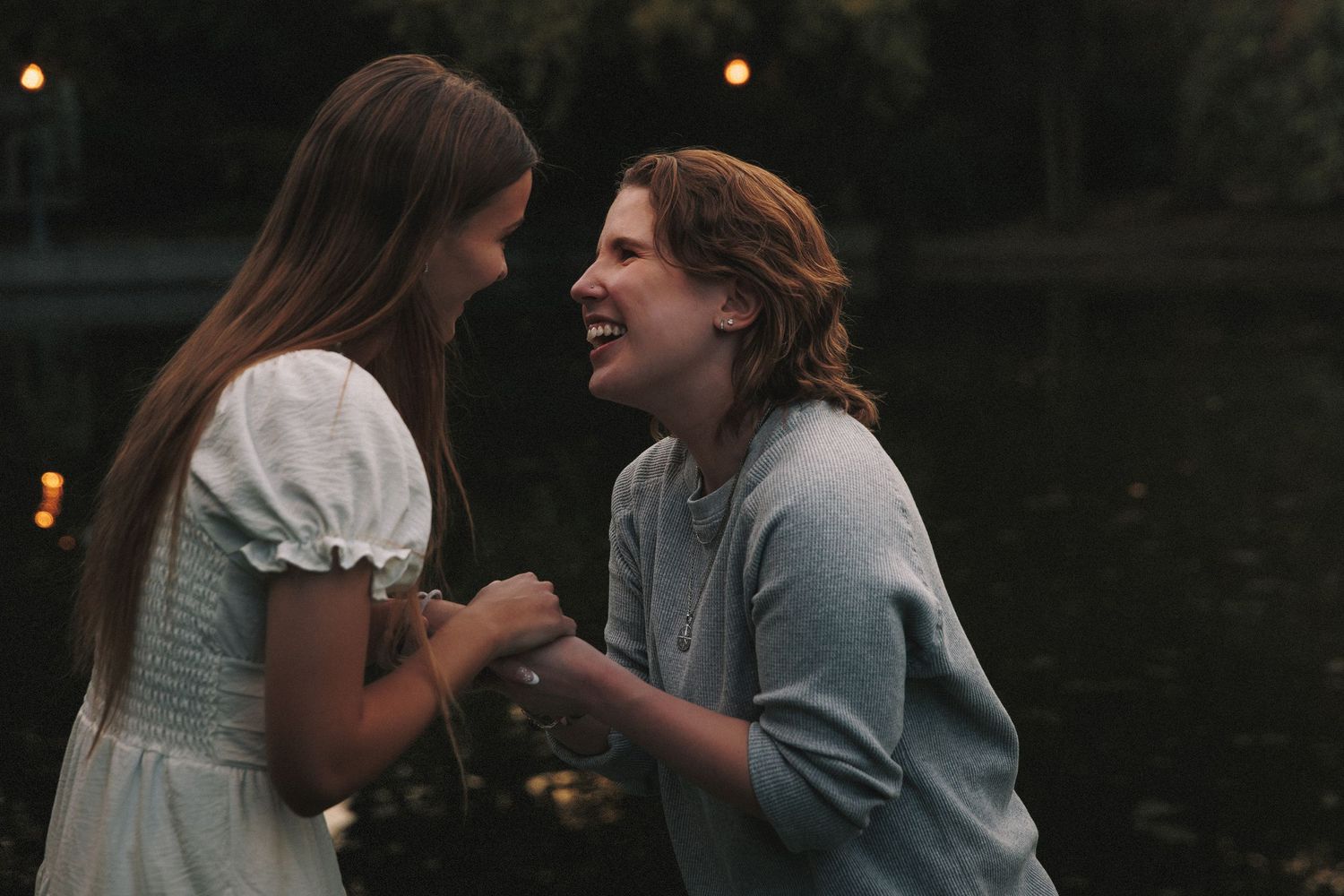 A couple shares an intimate moment together in a dimly lit setting with warm ambient lighting.