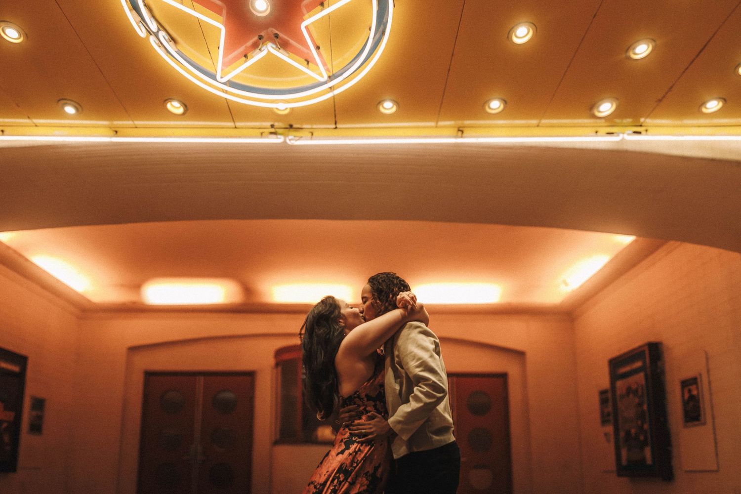 A luxurious hotel lobby features warm lighting, gold accents, and elegant architectural details on the ceiling.