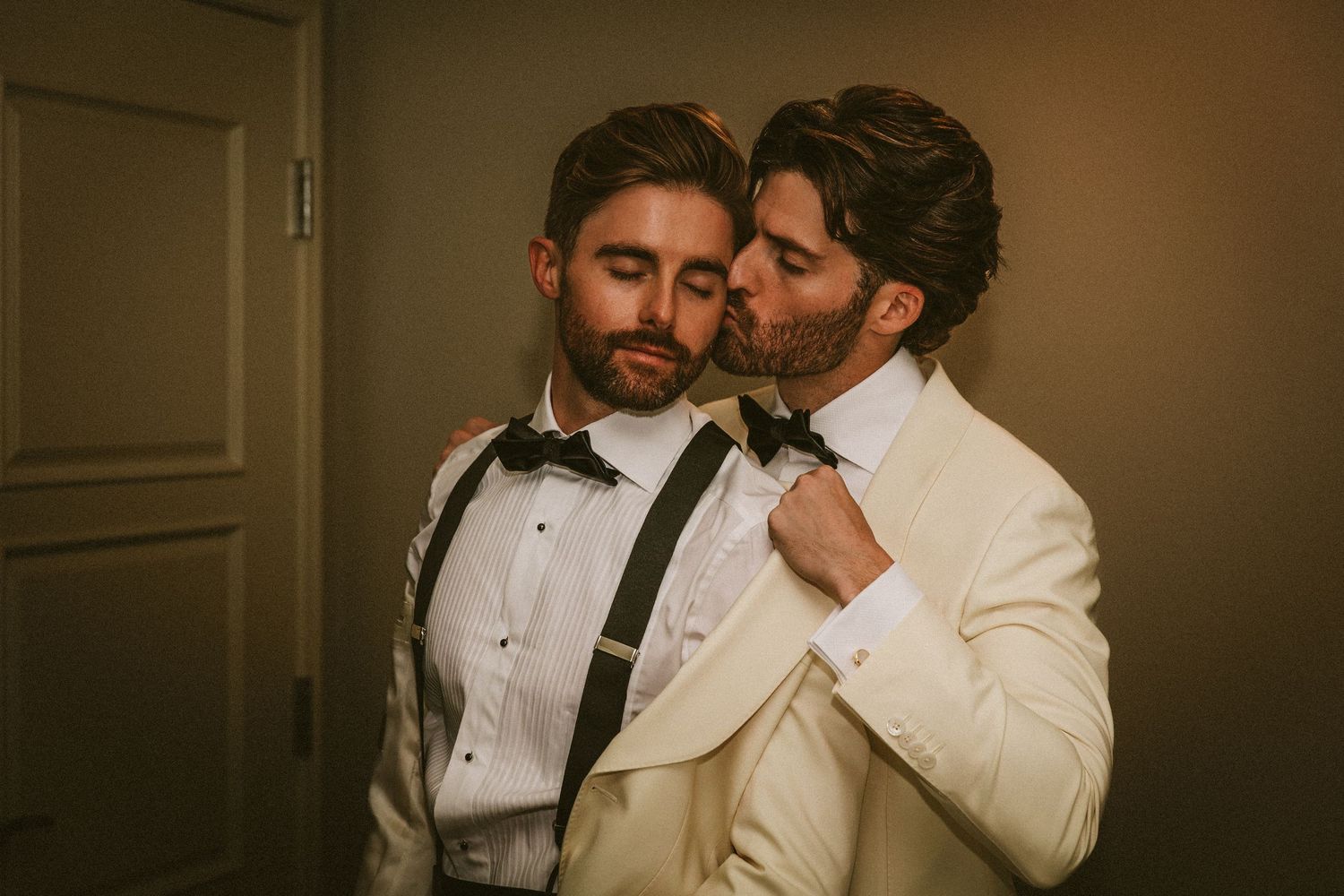 Two grooms sharing an intimate moment while getting ready for their wedding ceremony.