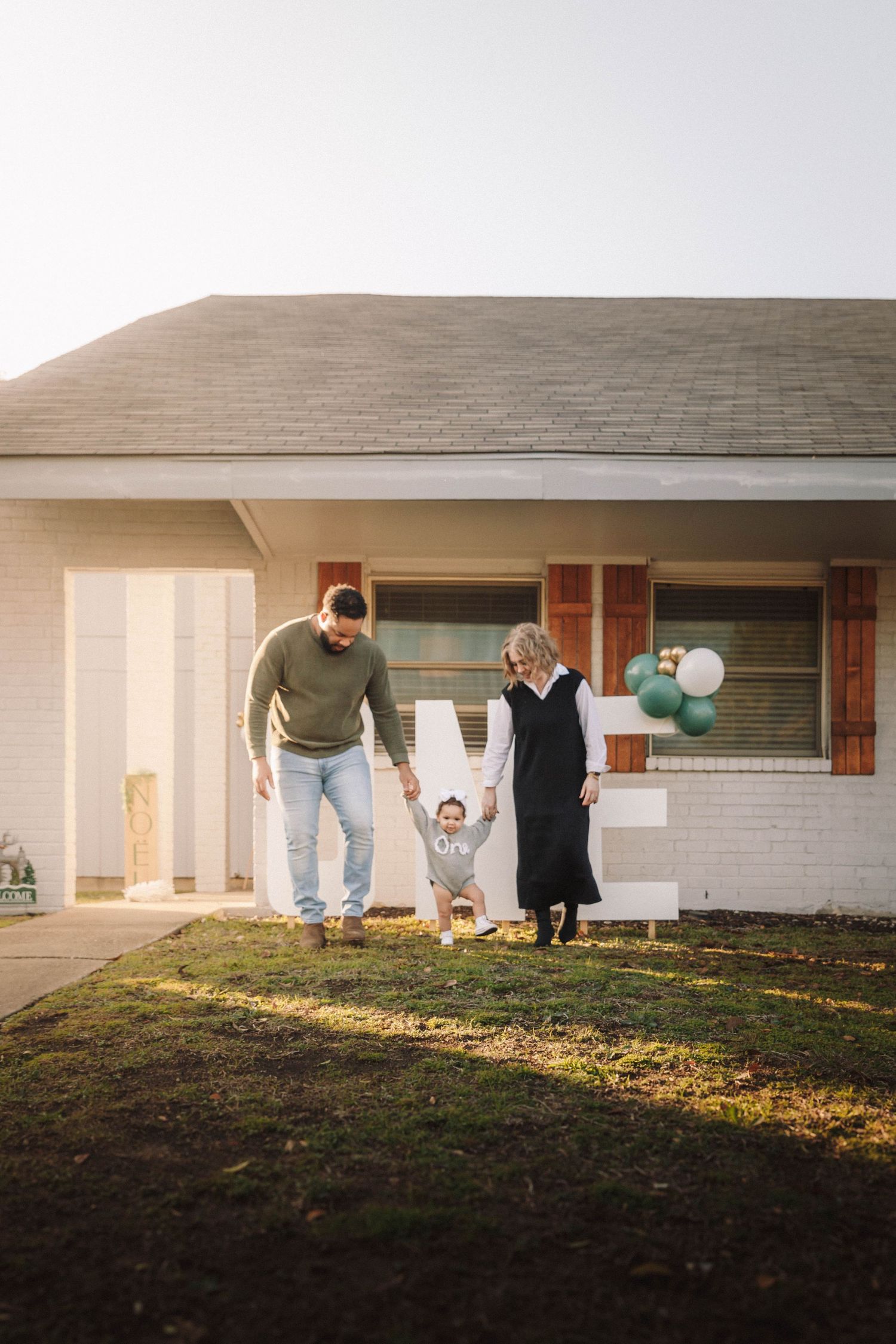 Family members play and interact in their backyard during golden hour sunlight.
