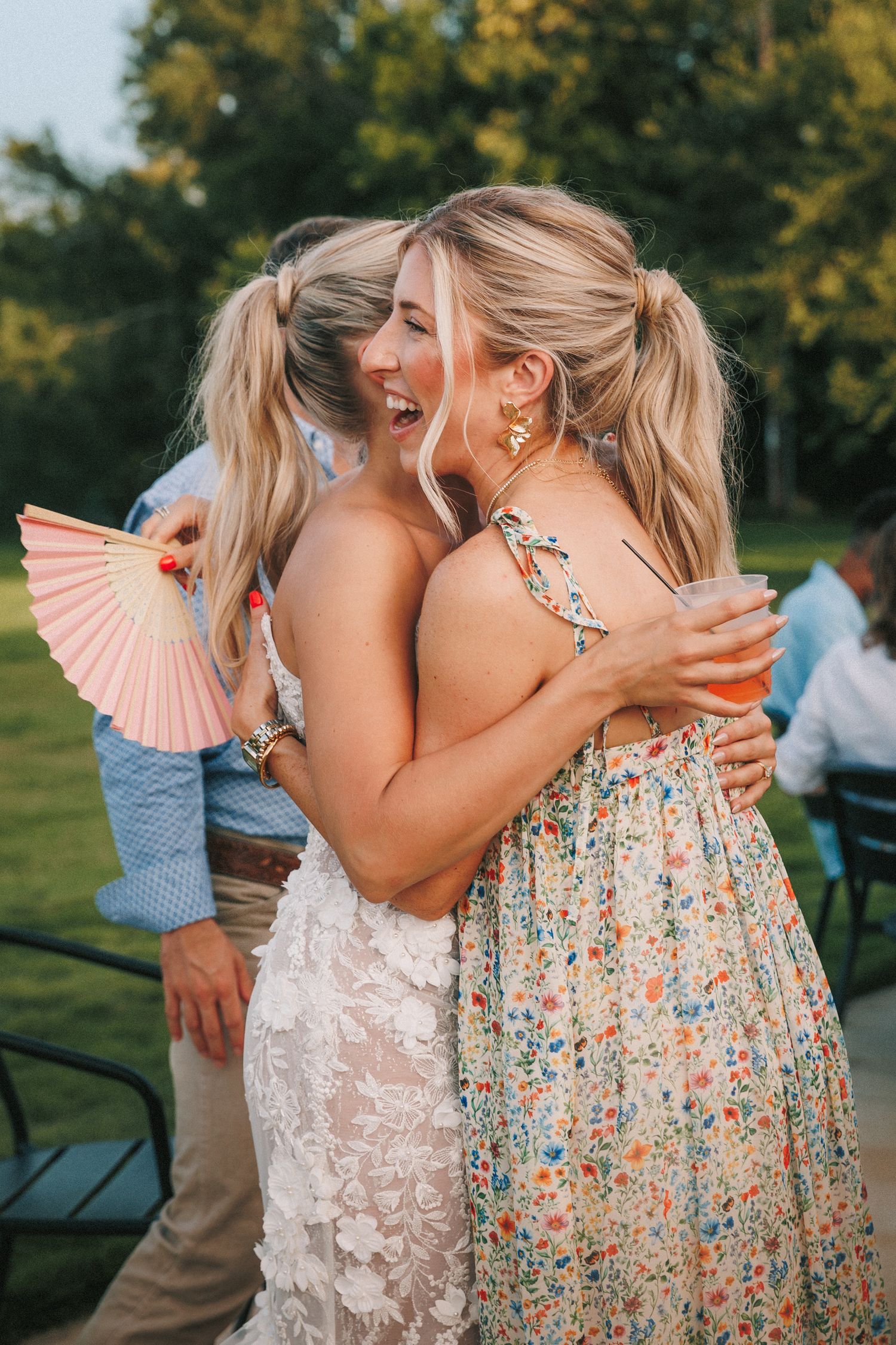 Wedding celebration moments with decorative paper fans and floral summer dresses.