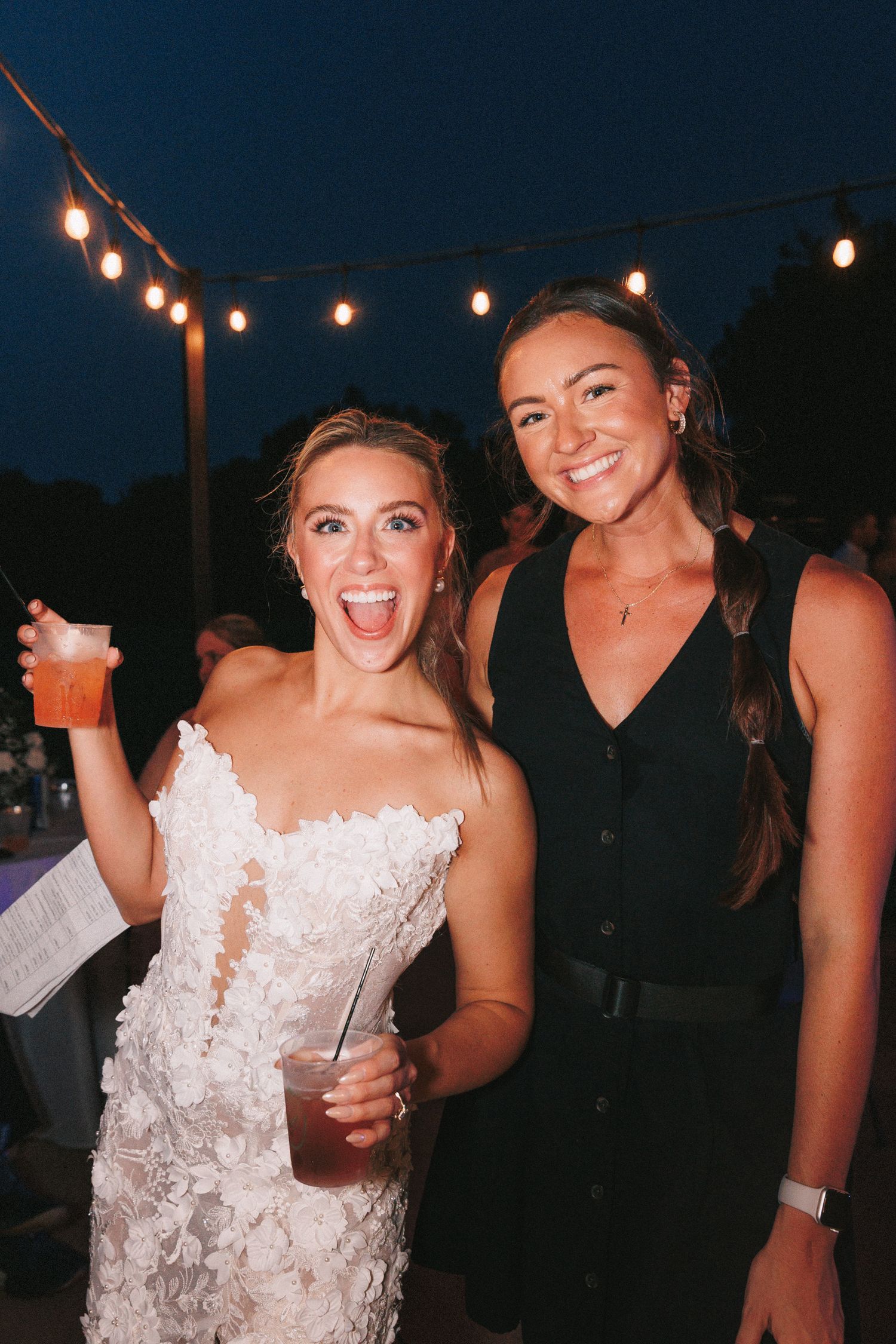 Wedding celebration at night with string lights creating a festive atmosphere.