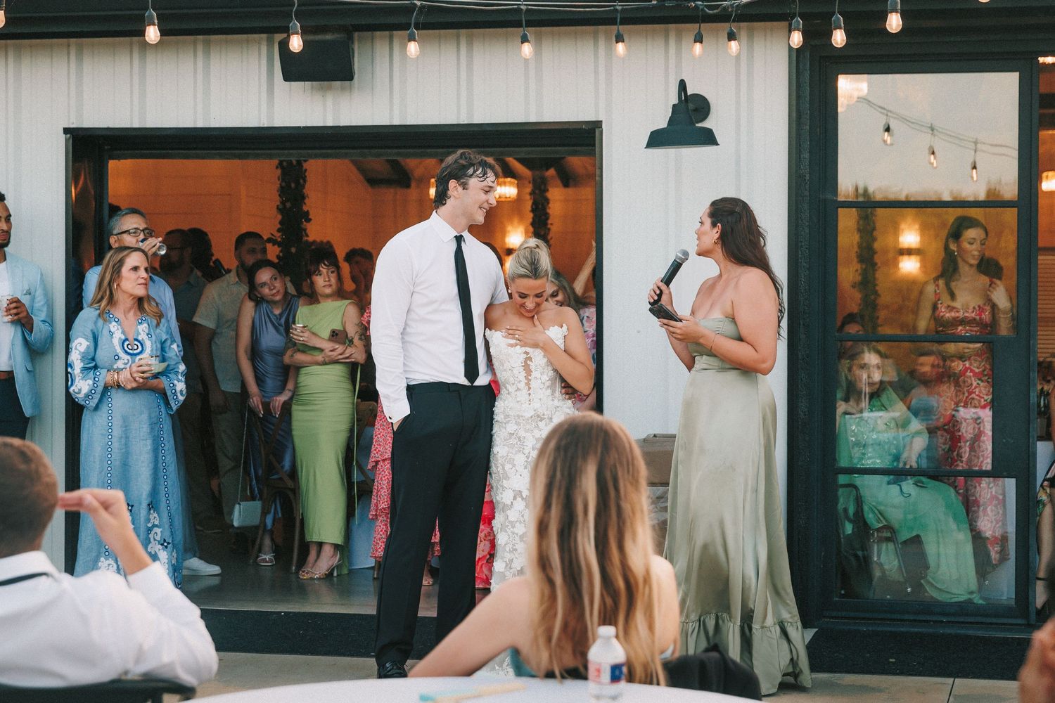 Reception venue decorated with hanging lights and large windows creating an elegant atmosphere.