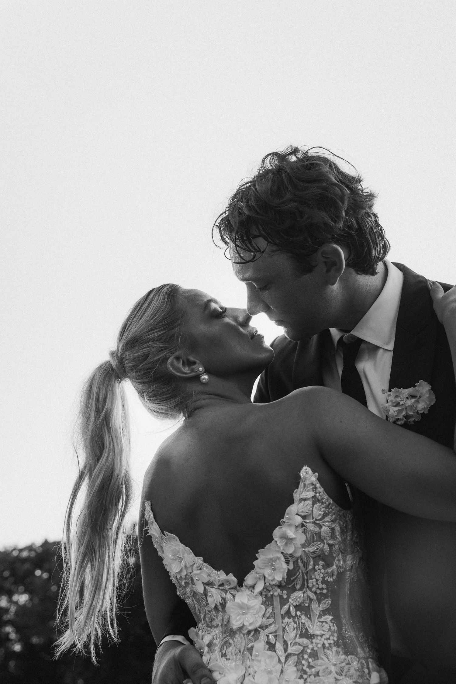 Black and white romantic wedding photos showing intimate moments between a couple in formal attire.