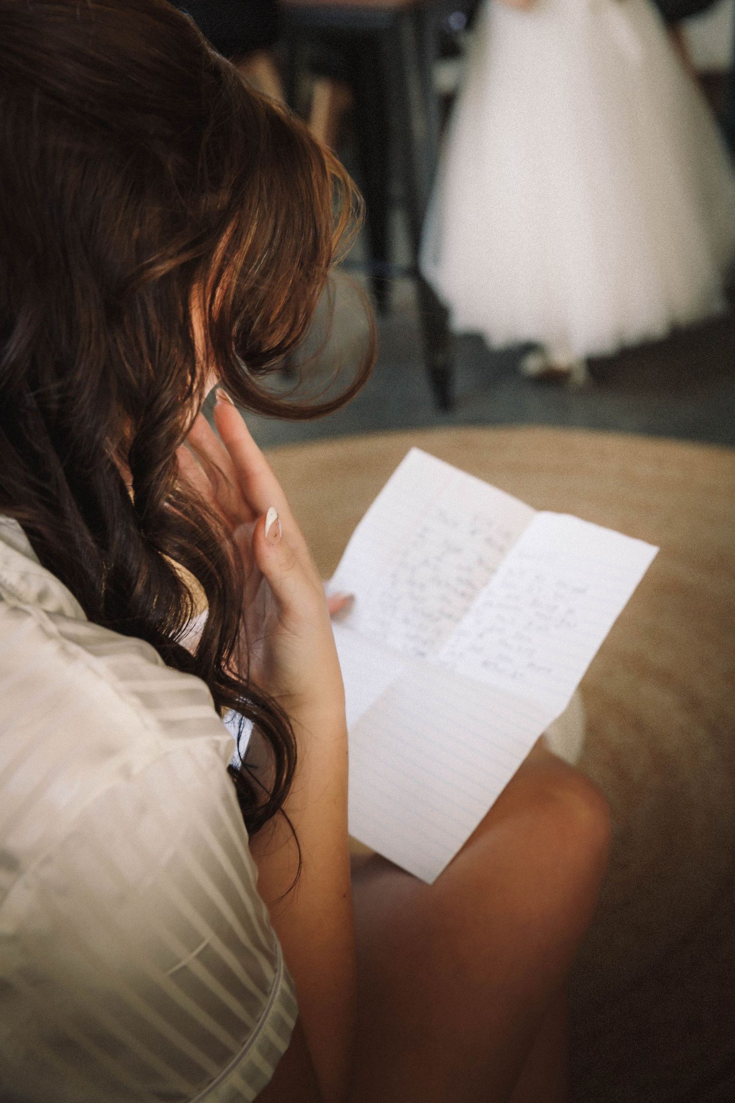 A series of photos showing a person in a white dress reading a handwritten letter in a dimly lit room.