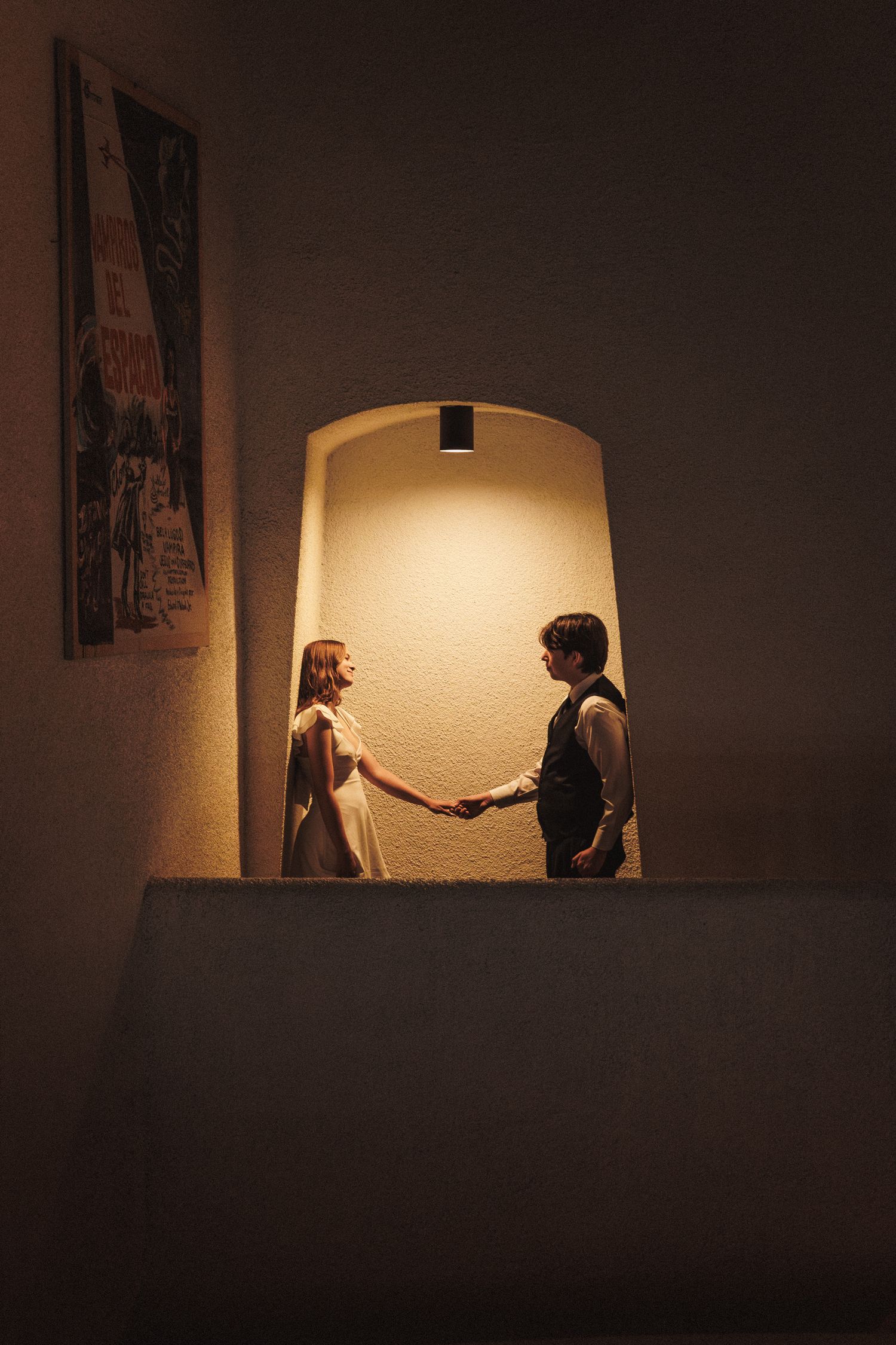 A dramatic sequence of silhouetted figures interacting in a dimly lit room with a glowing window arch in the background.