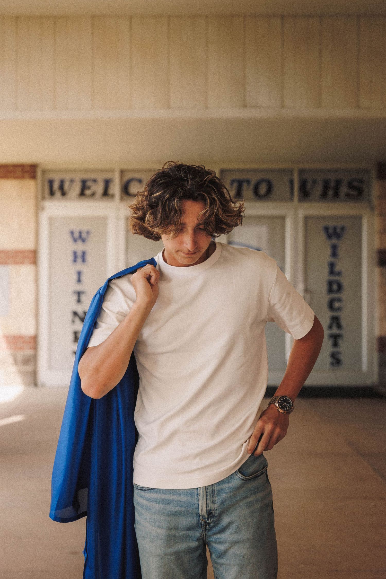 A hallway in a school shows a welcoming entrance with blue accents and lettering on the walls.