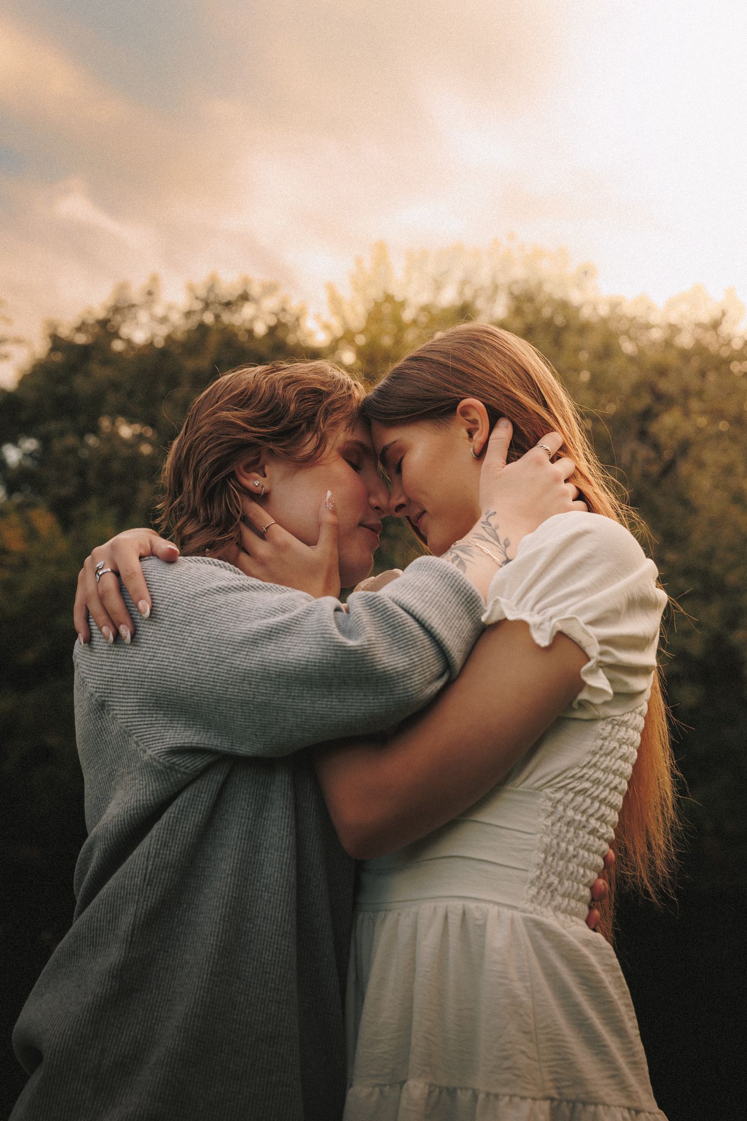 A couple embraces and kisses during golden hour in a romantic outdoor photoshoot sequence.