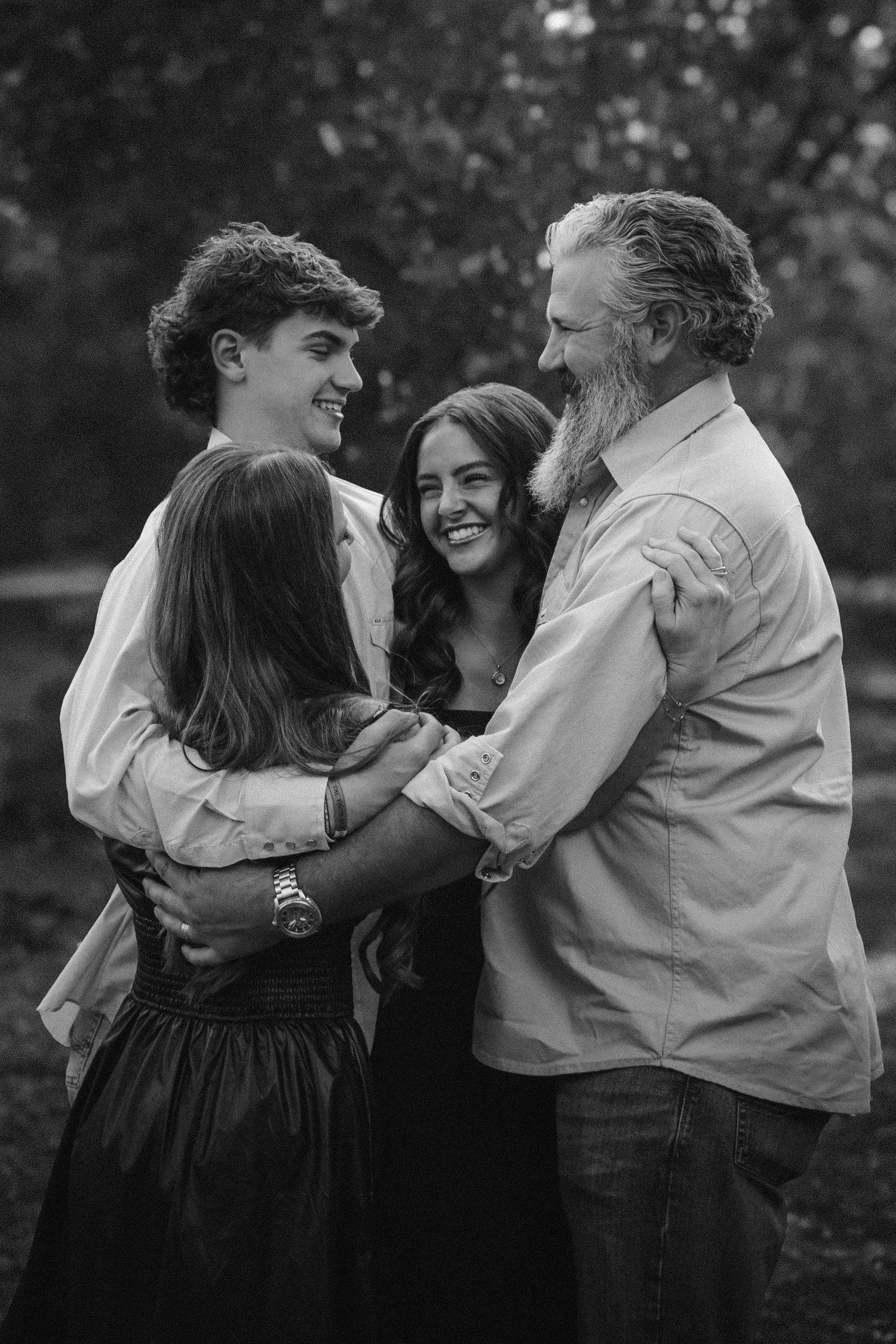 Black and white series captures candid moments of a couple embracing and laughing together outdoors.