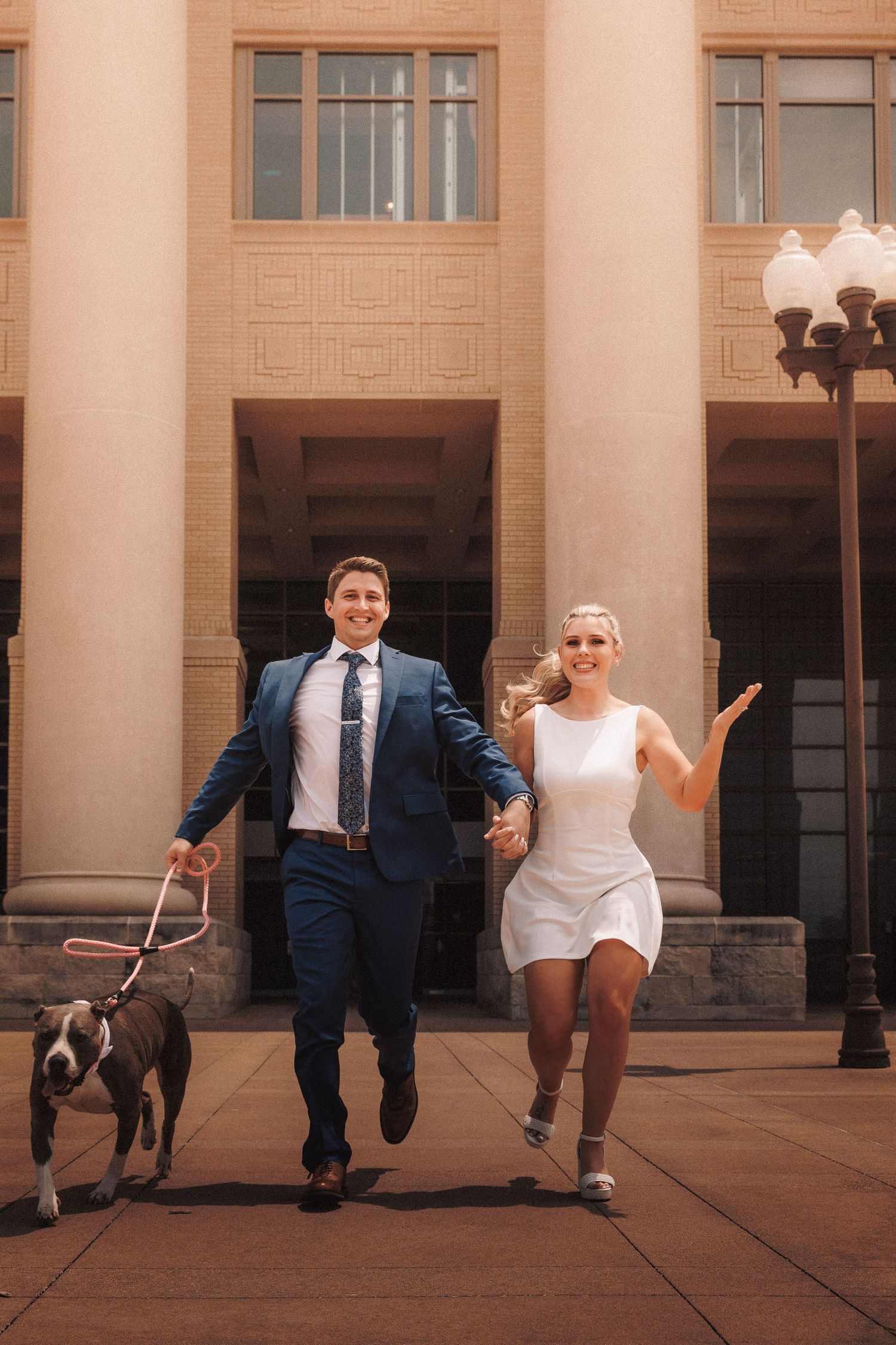 Wedding couple performs playful dance moves in sequence against a classic building with columns and lamp posts.