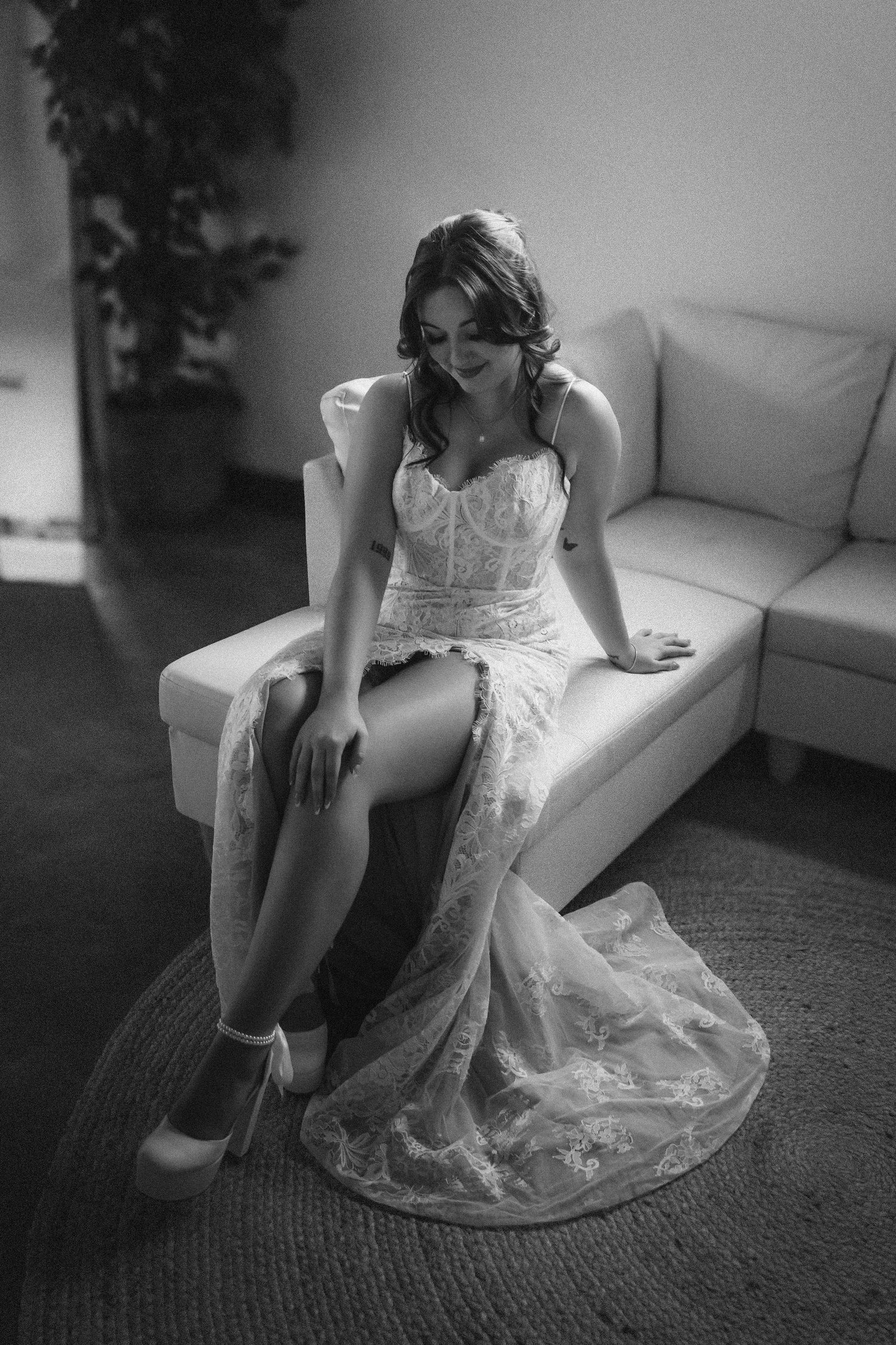Artistic black and white photo series showing someone sitting on a couch in flowing white lace dress.