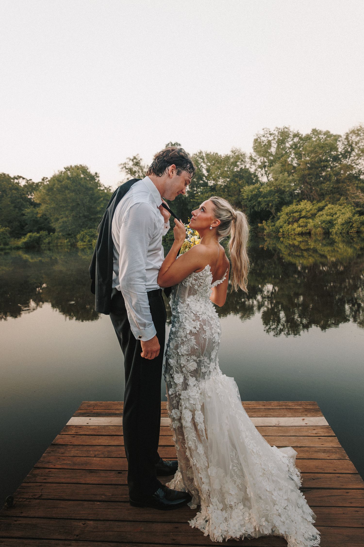 A couple sharing an intimate moment on a wooden dock by a lake.
