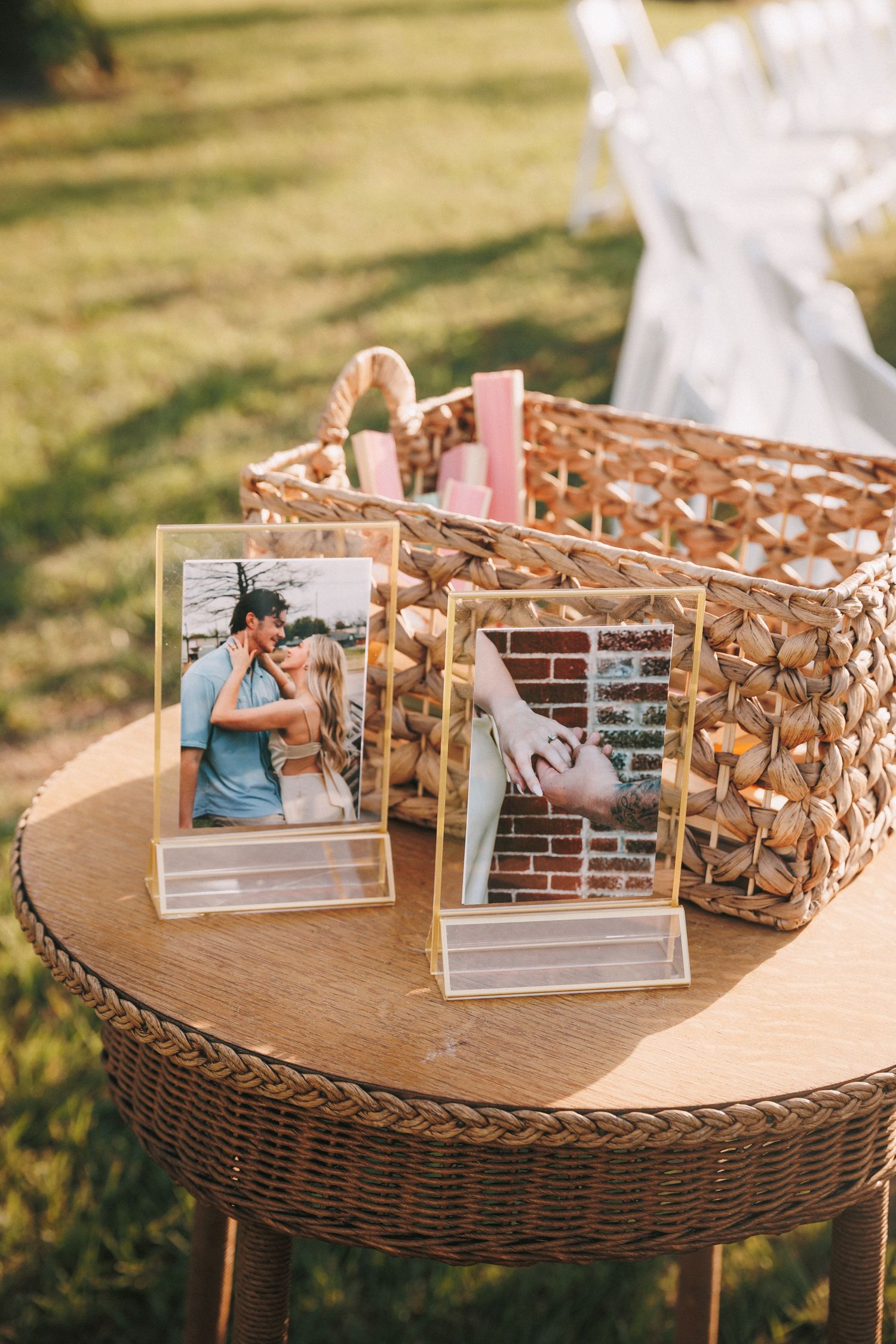 Rustic woven baskets display personal photos on a wooden table at an outdoor wedding reception.