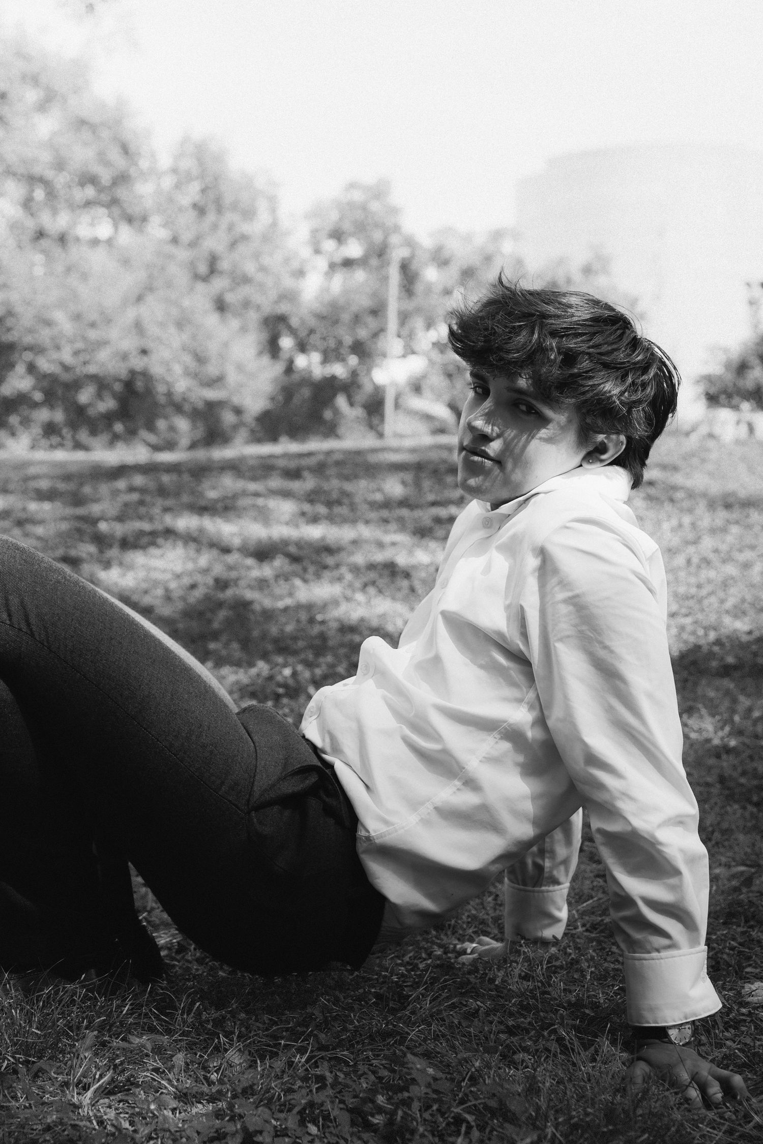 A sequence of black and white photographs showing someone in a white shirt lying in grass.