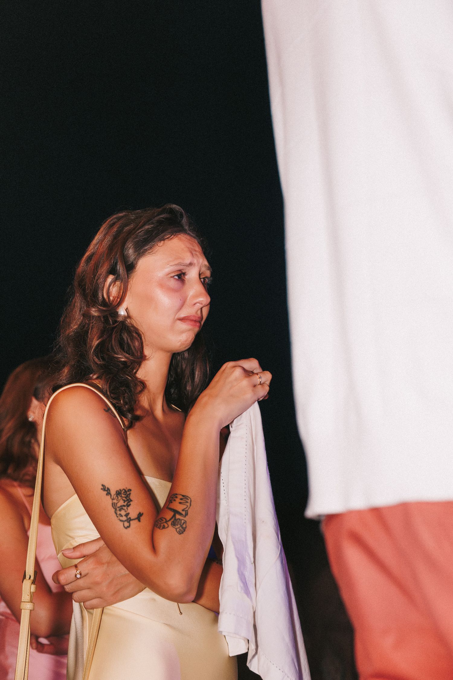A series of candid photos shows someone in a beige dress getting emotional while wiping tears during a special event.