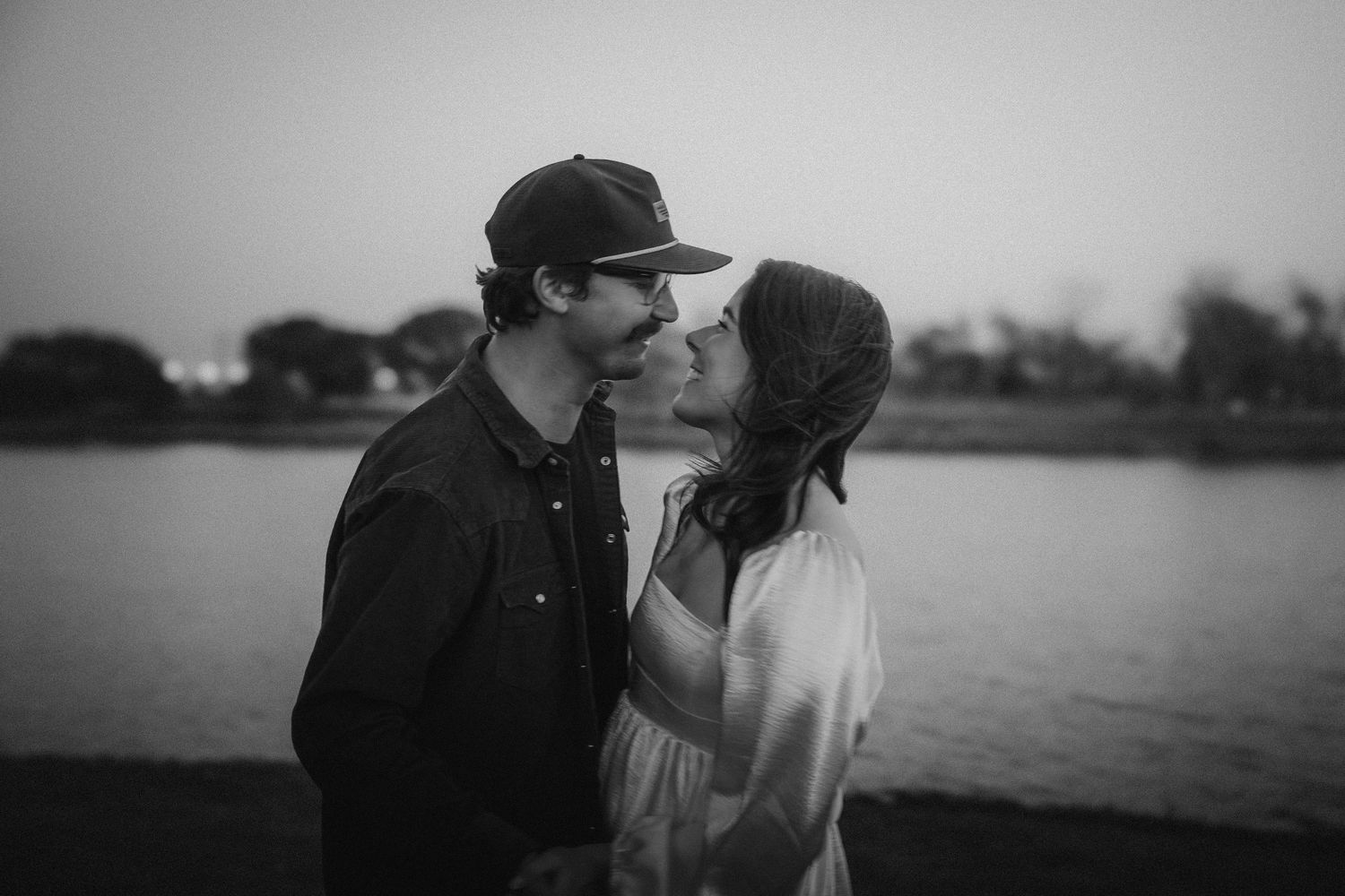 Silhouettes of two people against a misty horizon in black and white photography.