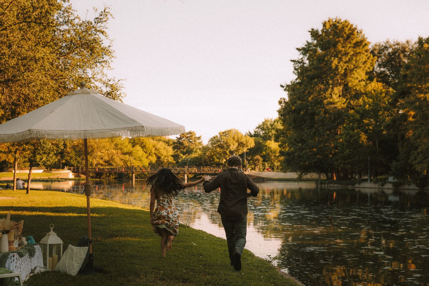 Golden sunset illuminates autumn trees and white tents at an outdoor event venue.
