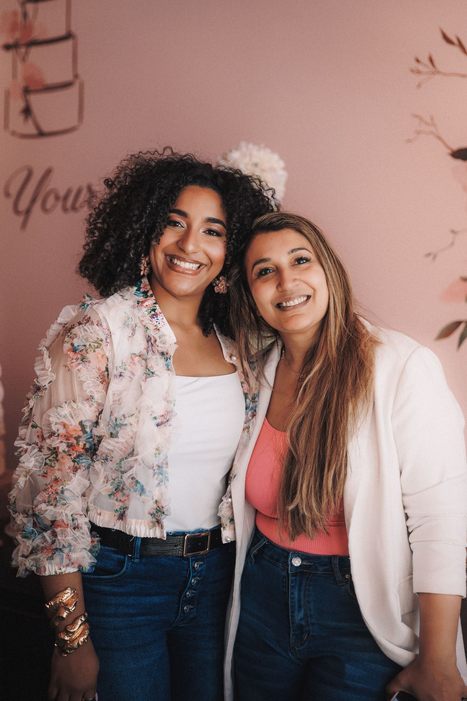 A series of candid photos showing two friends laughing and posing together against a pink wall.