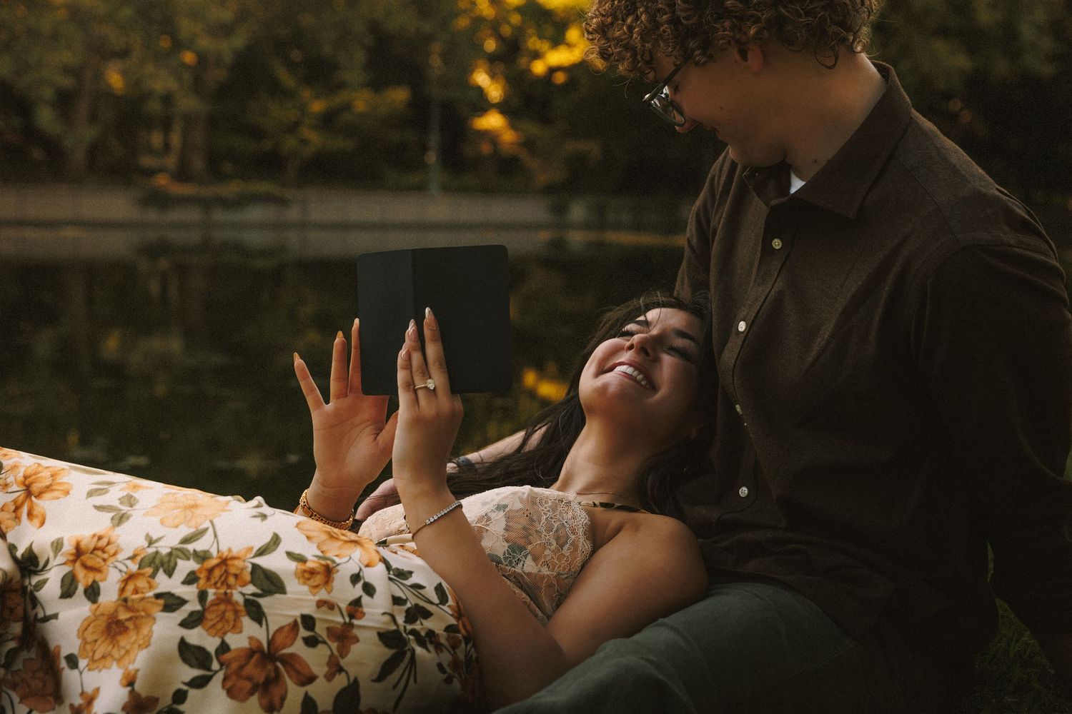 Intimate couple's photoshoot on blankets during golden hour.