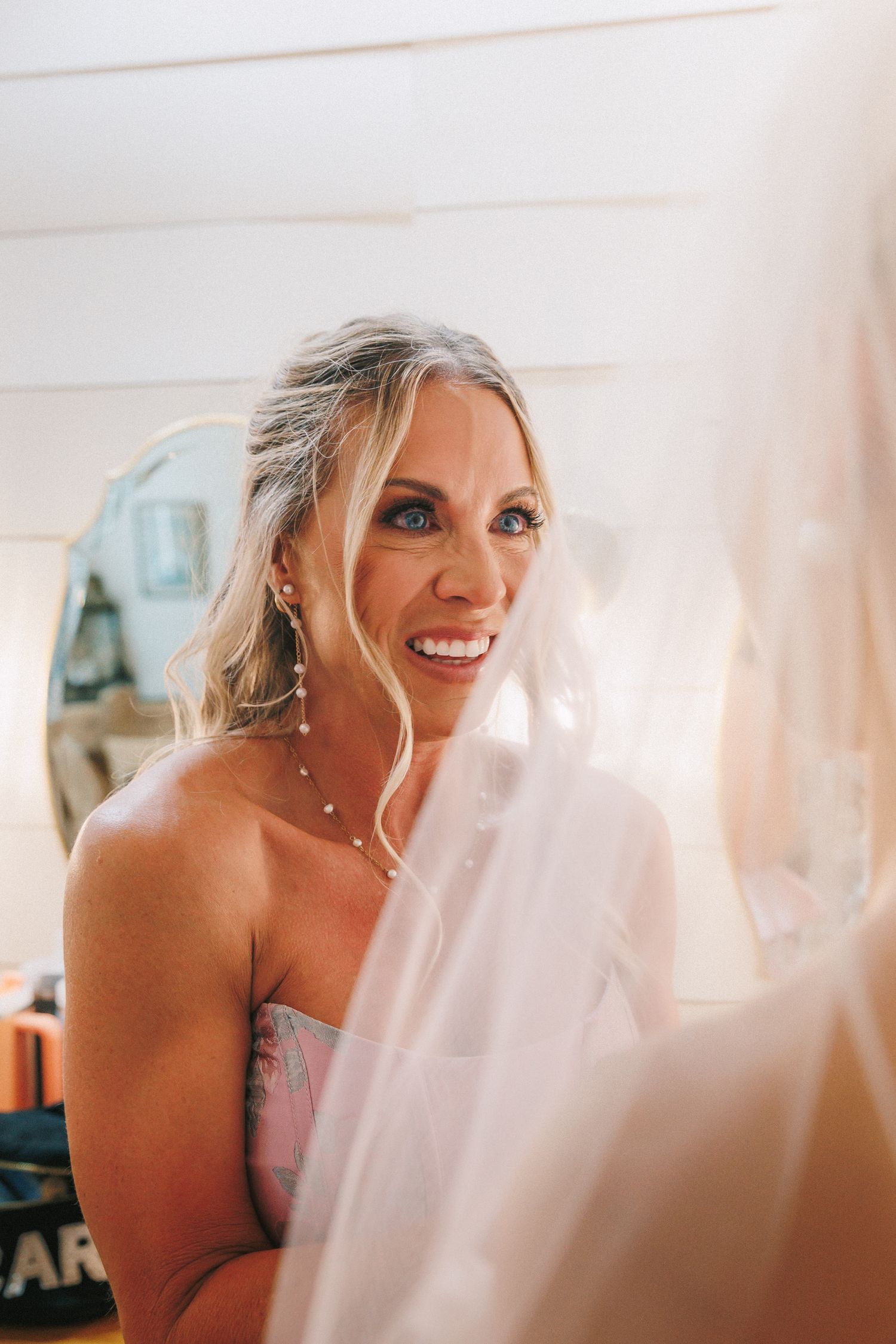 Getting ready moments captured through soft focus and natural window light.