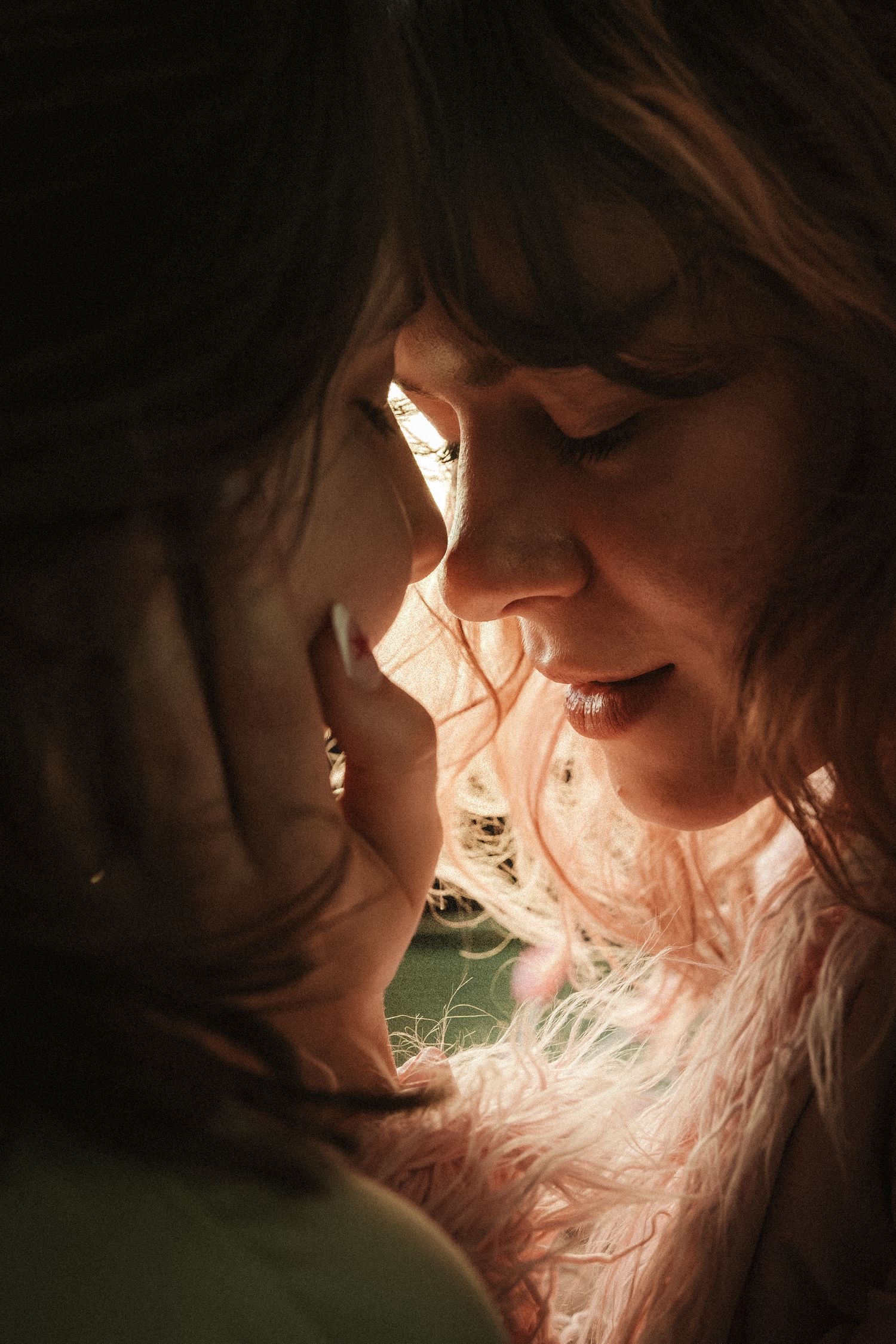 Intimate close-up portrait of two faces in warm lighting with soft shadows and romantic atmosphere.