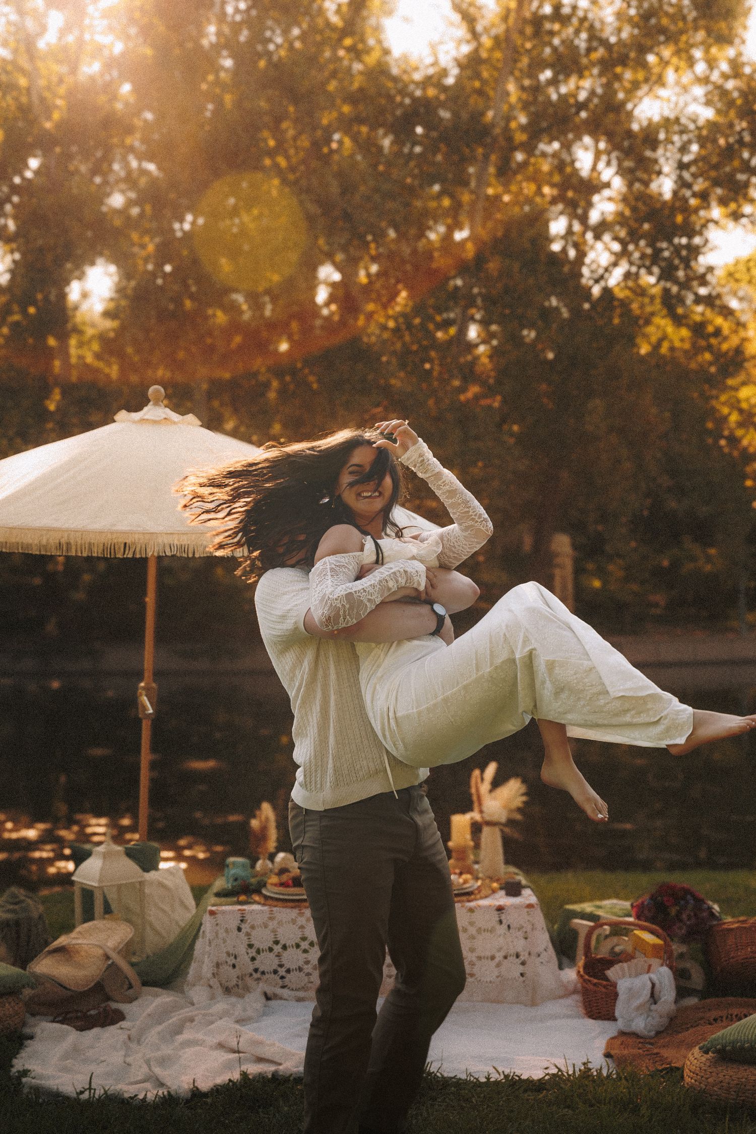 A romantic couple dances together at sunset in a backyard garden setting with warm golden lighting.