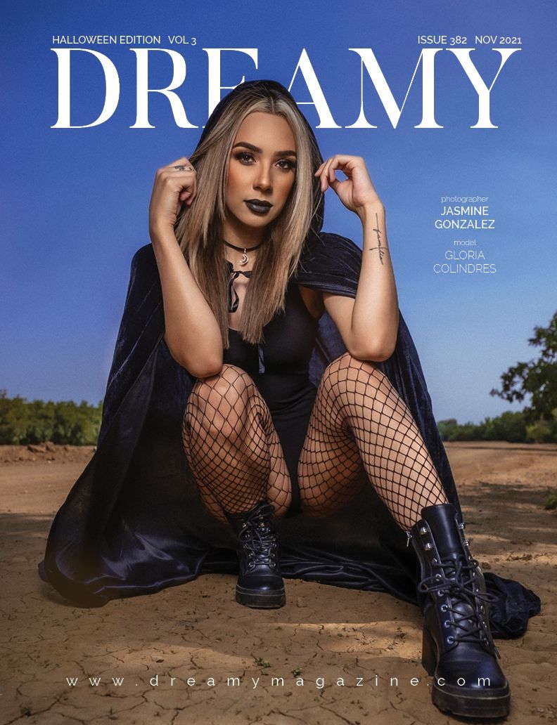 Dark gothic fashion magazine cover showing model in black dress and fishnet stockings against desert backdrop.